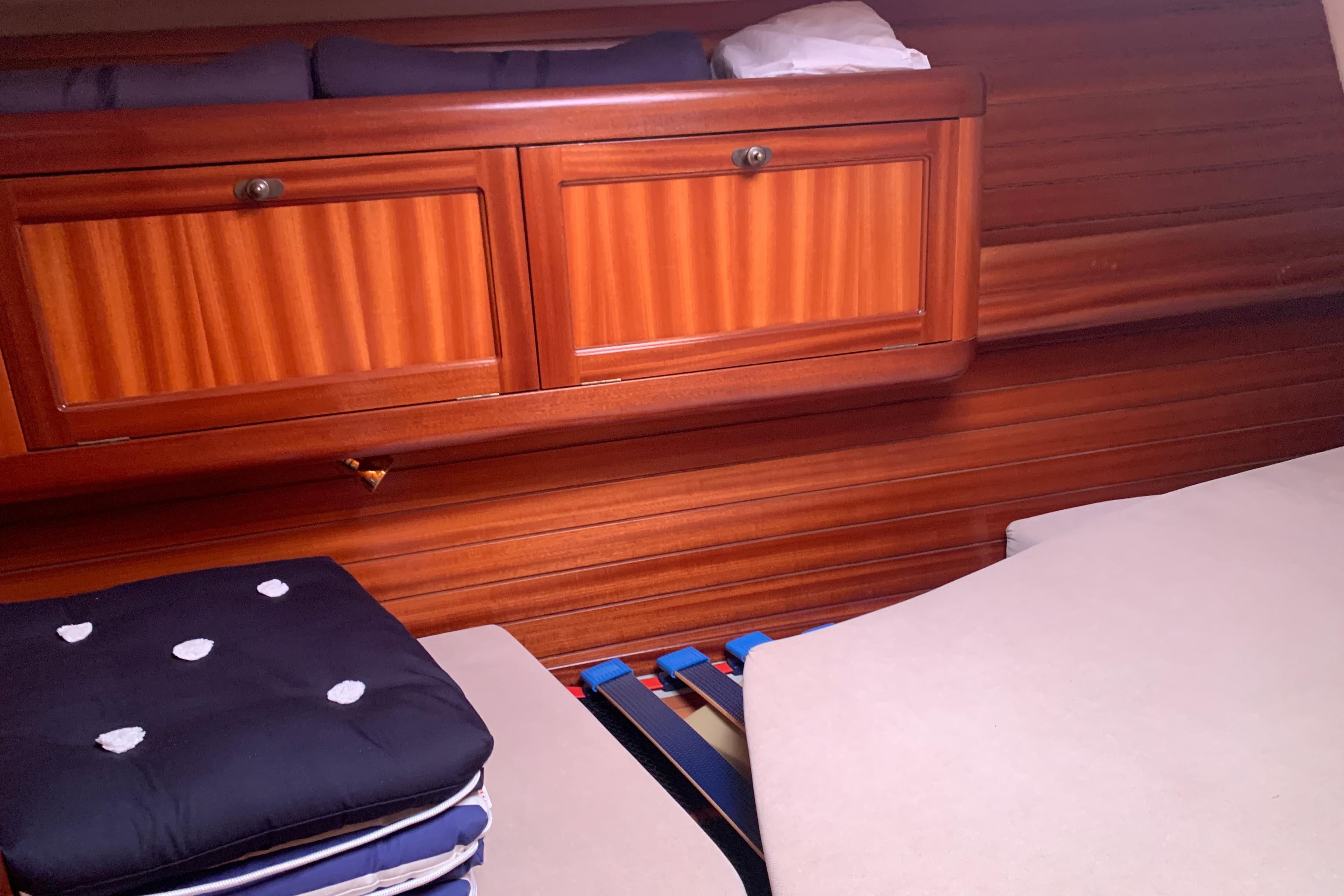 Interior of a 2000 Sunbeam 37 yacht with wooden cabinetry and folded bedding.