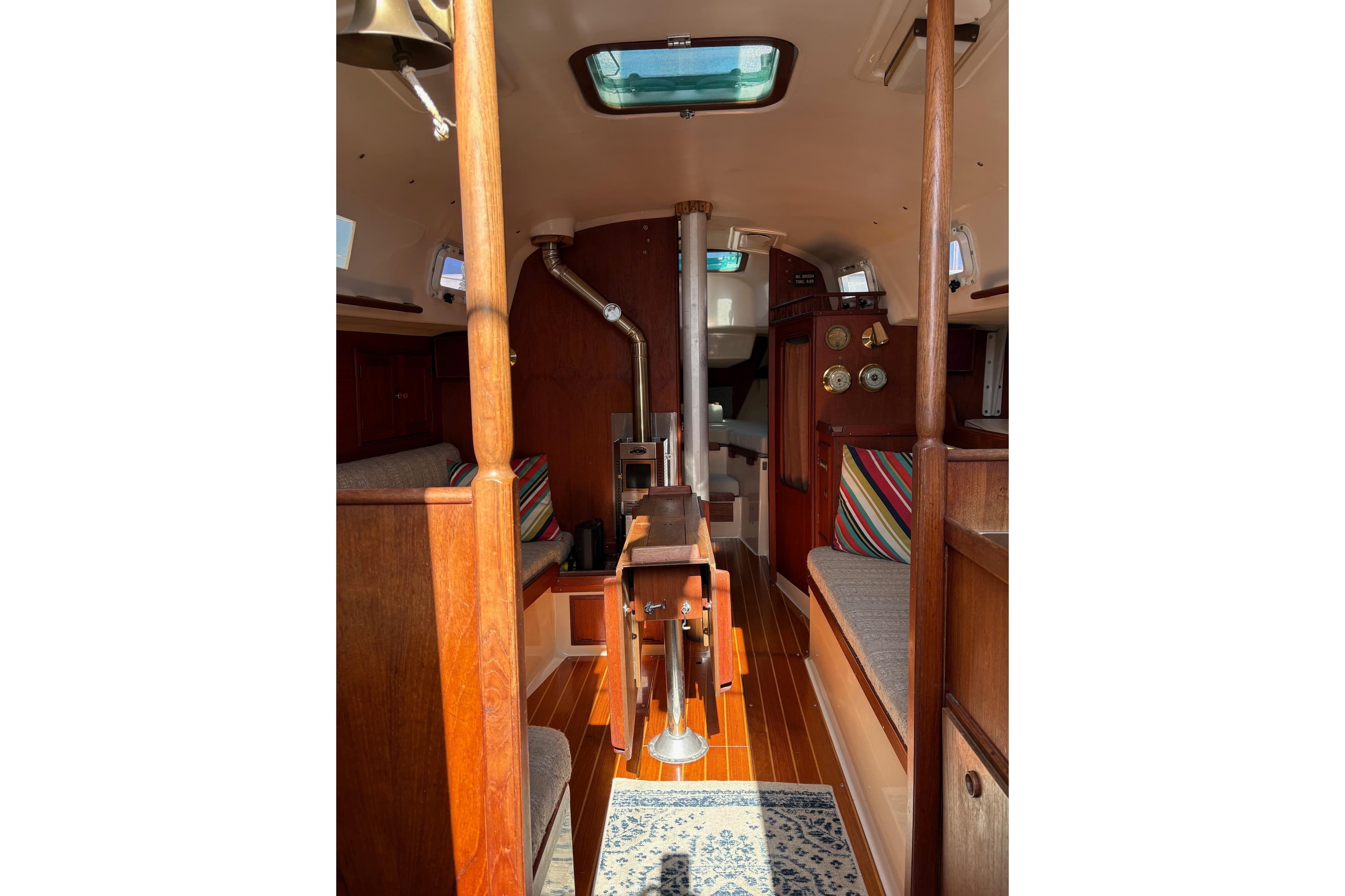 Interior of a 1980 Ontario 32 sailboat, featuring wood finishes and colorful cushions.