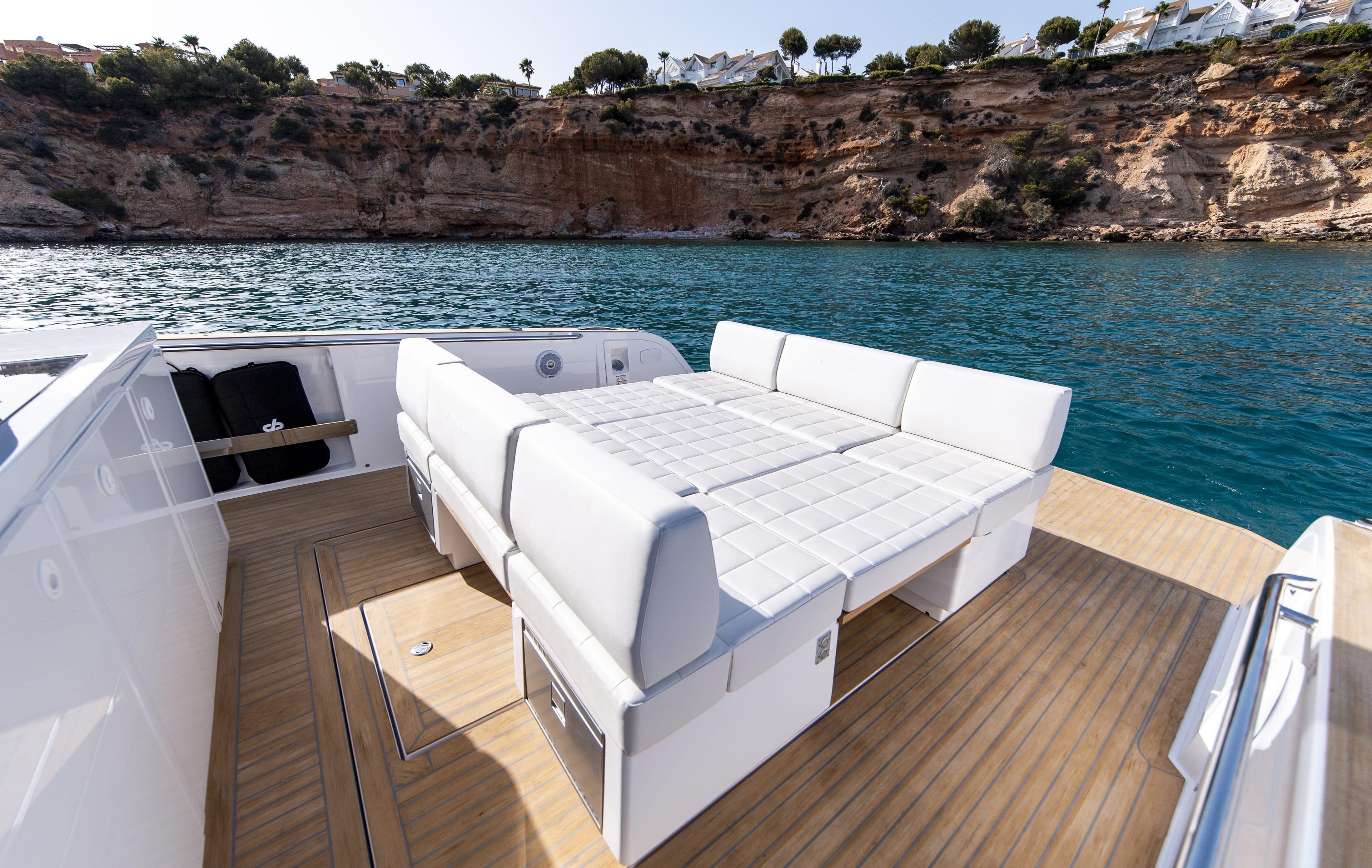 Luxury Pardo Yachts 38, 2020 model, with elegant seating, docked by scenic cliffs.
