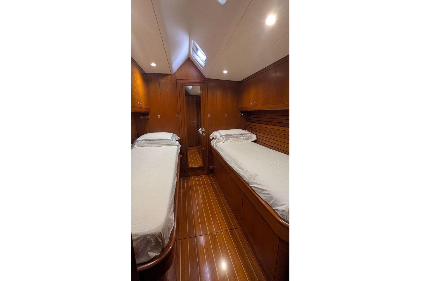 Luxurious wooden cabin interior of 2007 Nautor Swan 75 yacht with twin beds.