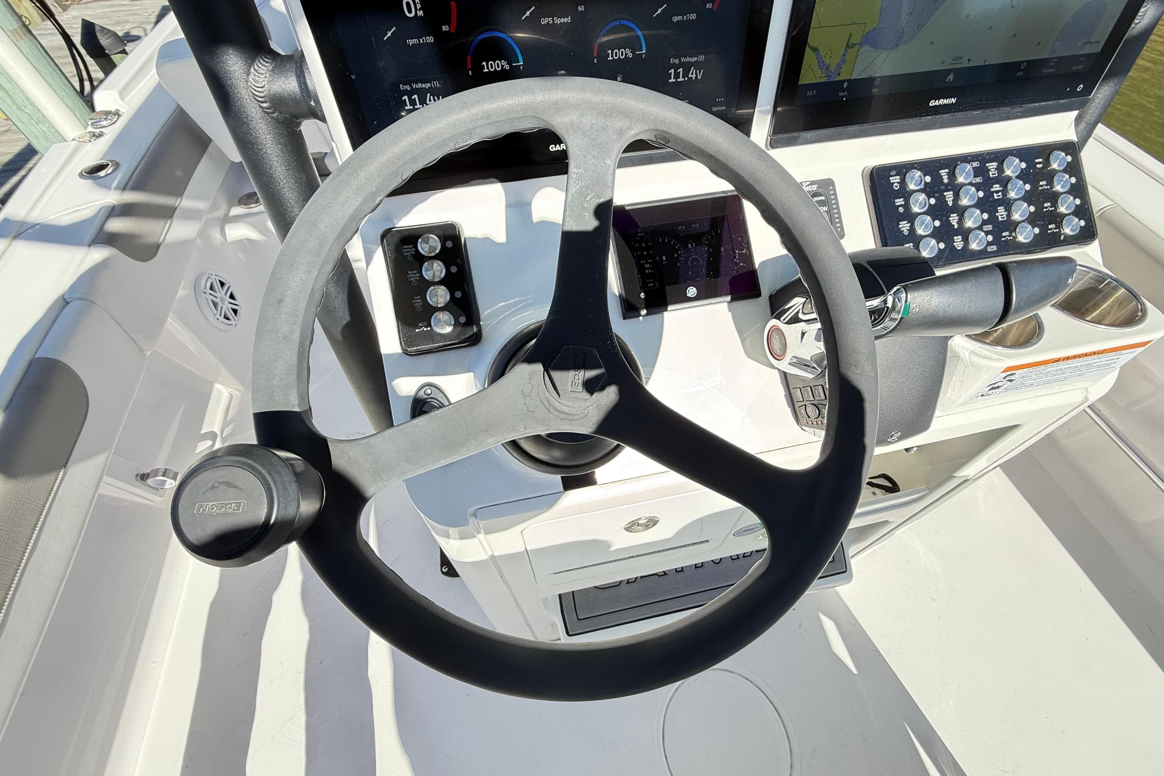 Steering wheel and dashboard of 2023 Caymas 281 HB boat, featuring modern controls.