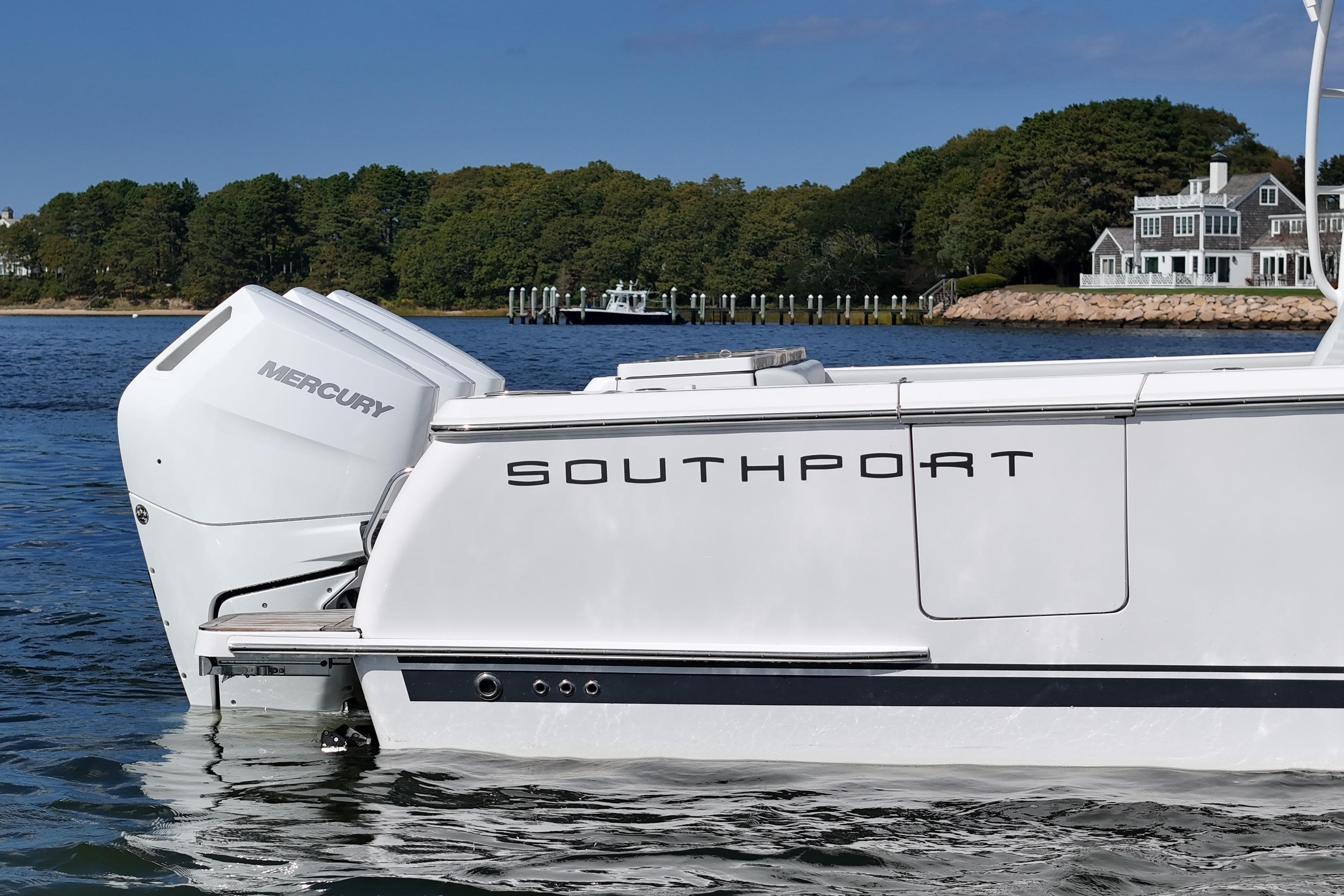 2025 Southport 38 FE boat with Mercury engines on a scenic waterfront.