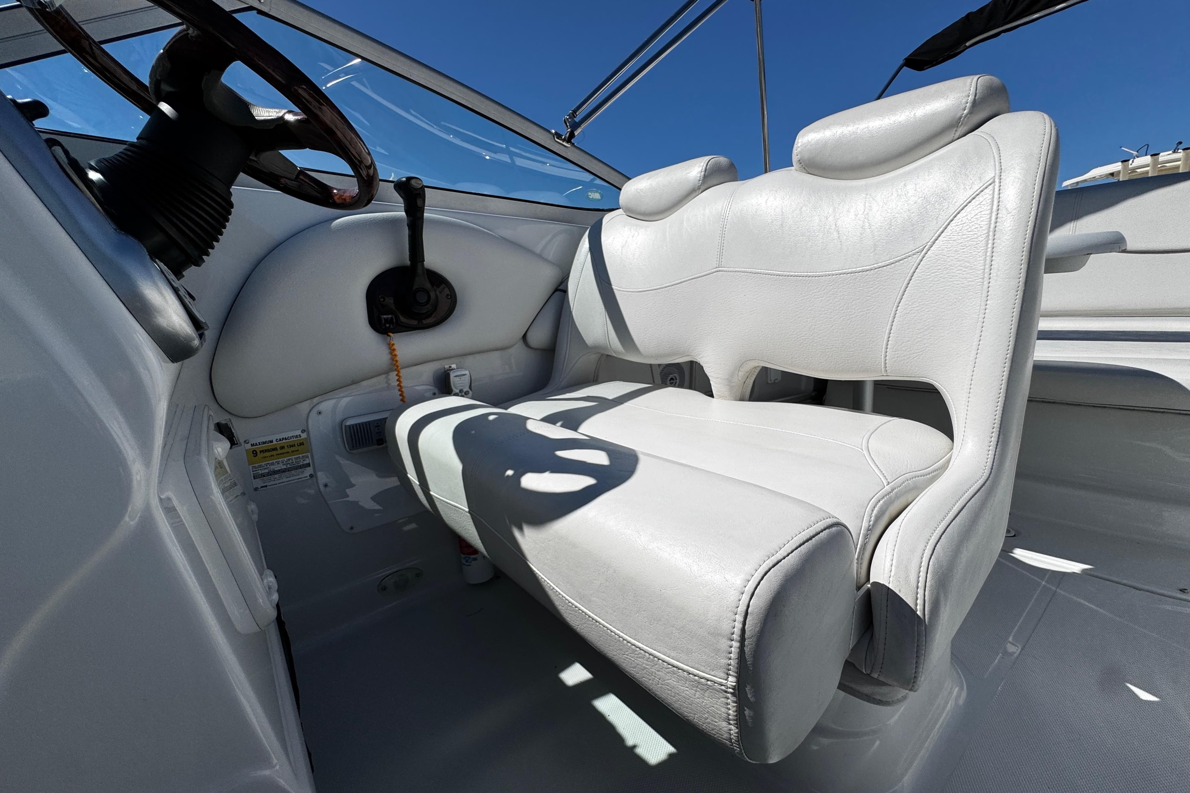 2004 Crownline 250 CR boat interior with white leather seating and steering wheel.