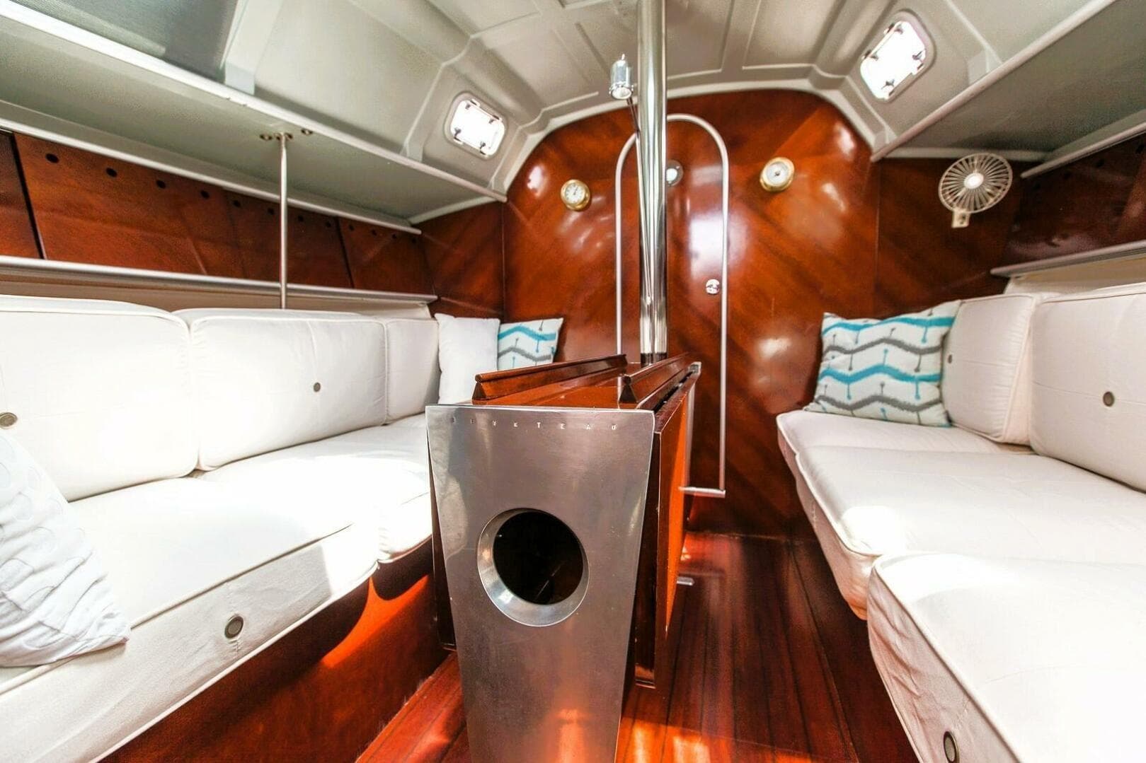 Interior of 1989 Beneteau First 35s5 sailboat with white seating and wooden accents.