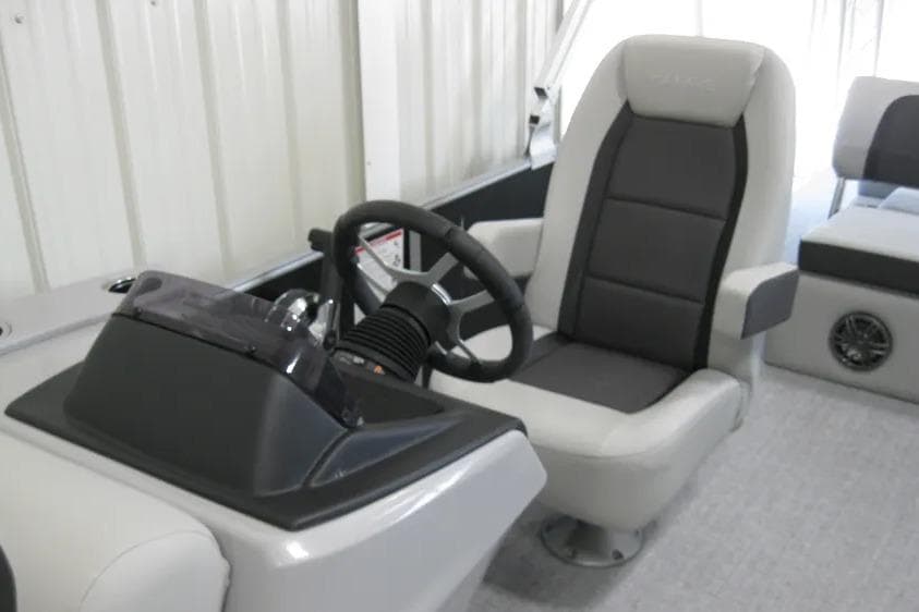 2025 Harris FloteBote 230 Cruiser interior with steering wheel and captain's chair.