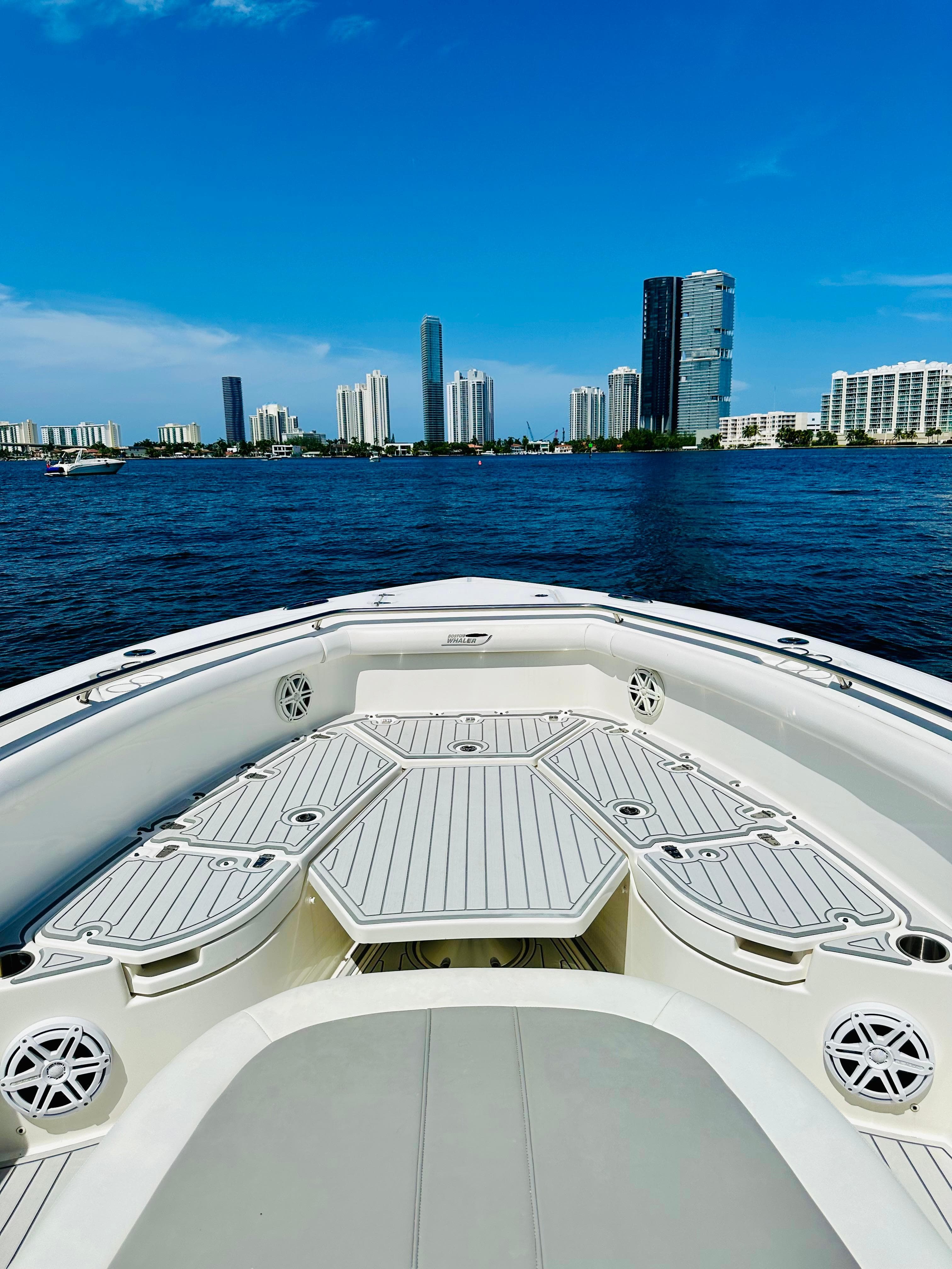 2016 Boston Whaler 350 Outrage boat cruising with city skyline in background.