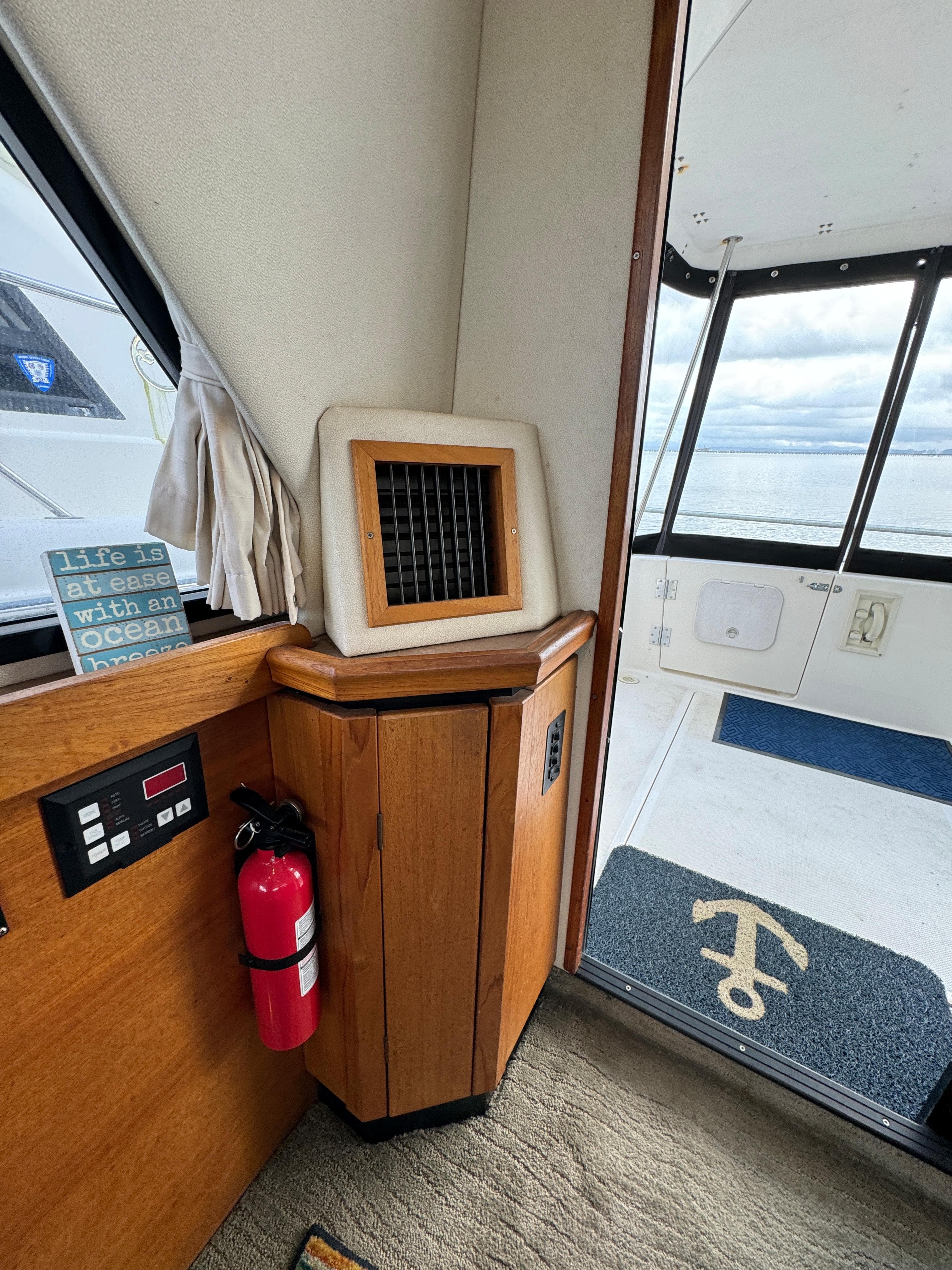 1996 Bayliner 3388 Command Bridge Motoryacht interior with fire extinguisher and sea view.