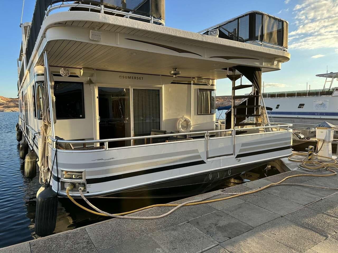 2005 Sumerset Top Hat houseboat docked, featuring multiple decks and modern design.