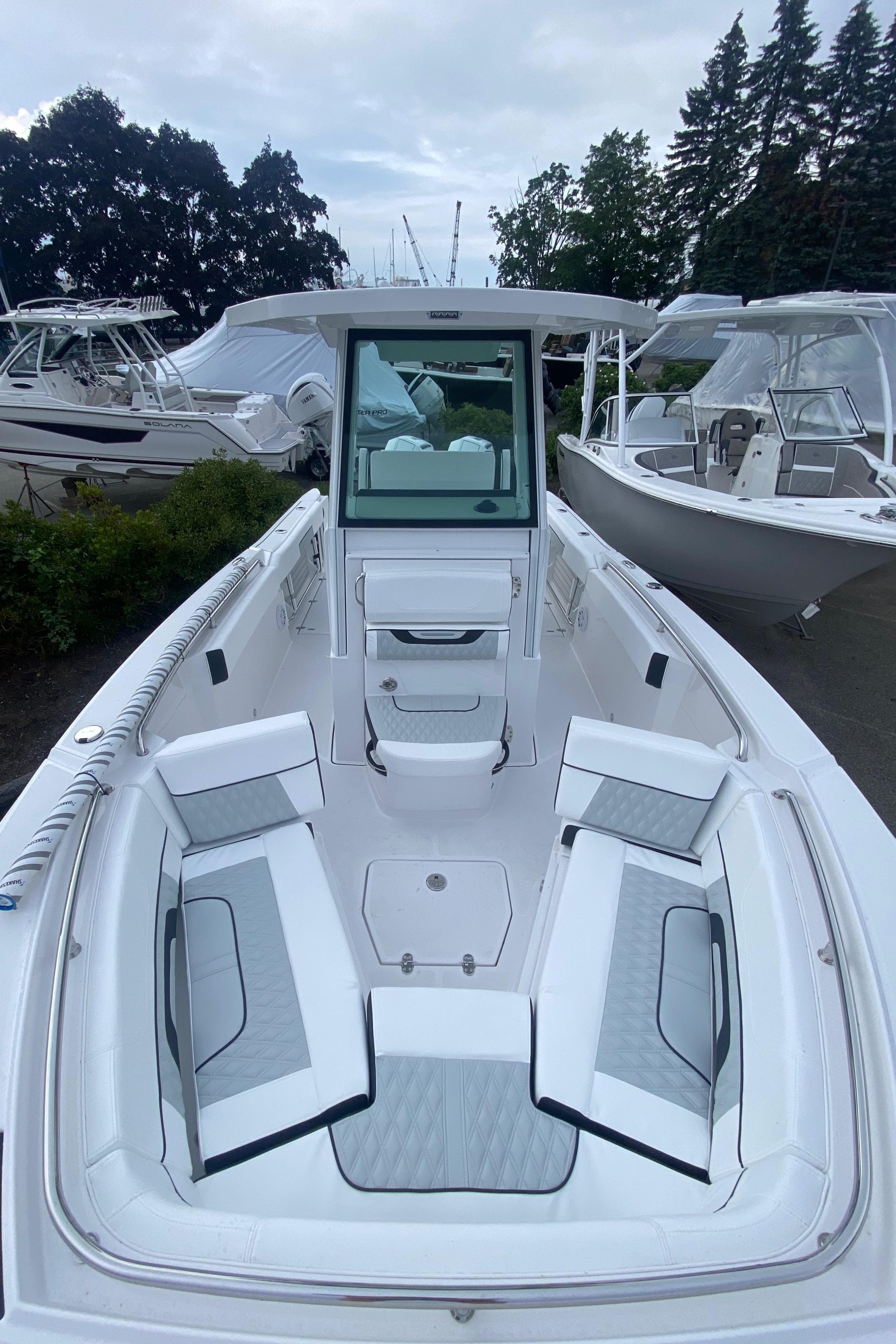 2025 Blackfin 252 CC boat with spacious seating, docked among other boats.