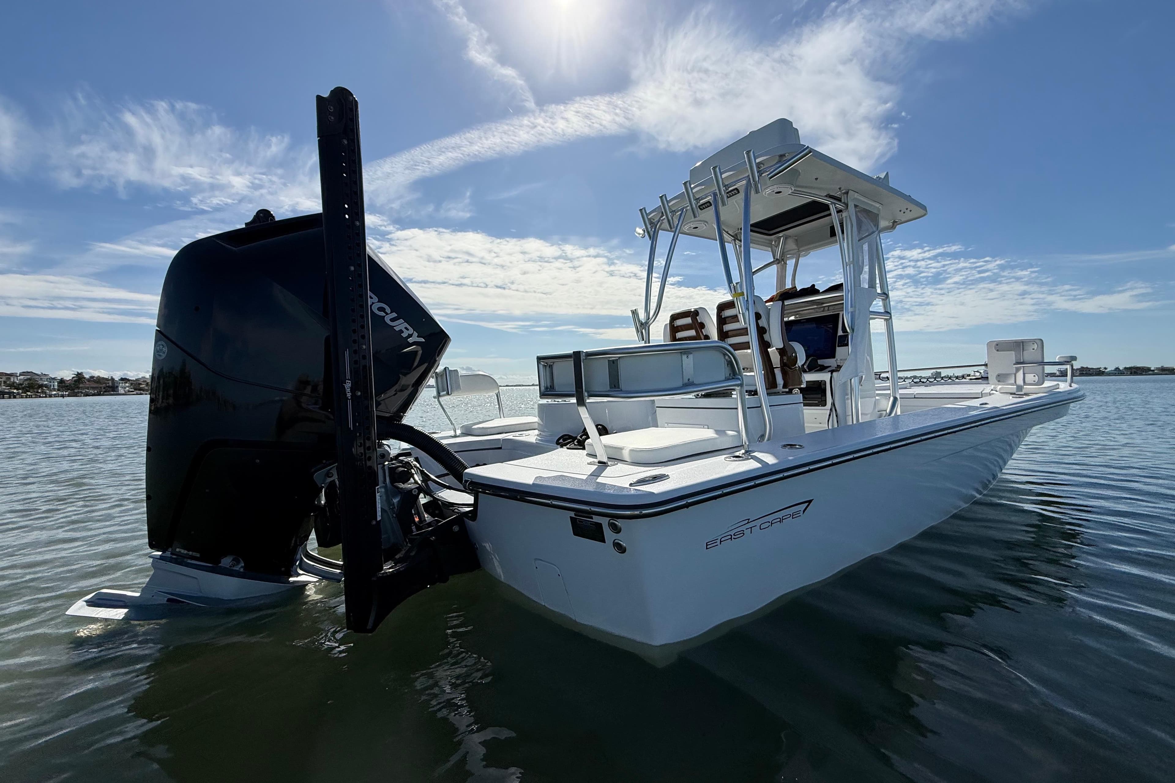 2024 East Cape 25 Hybrid boat on calm water under a clear sky.