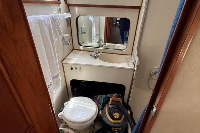 1988 Chris-Craft 381 Catalina bathroom with sink, mirror, and toilet.