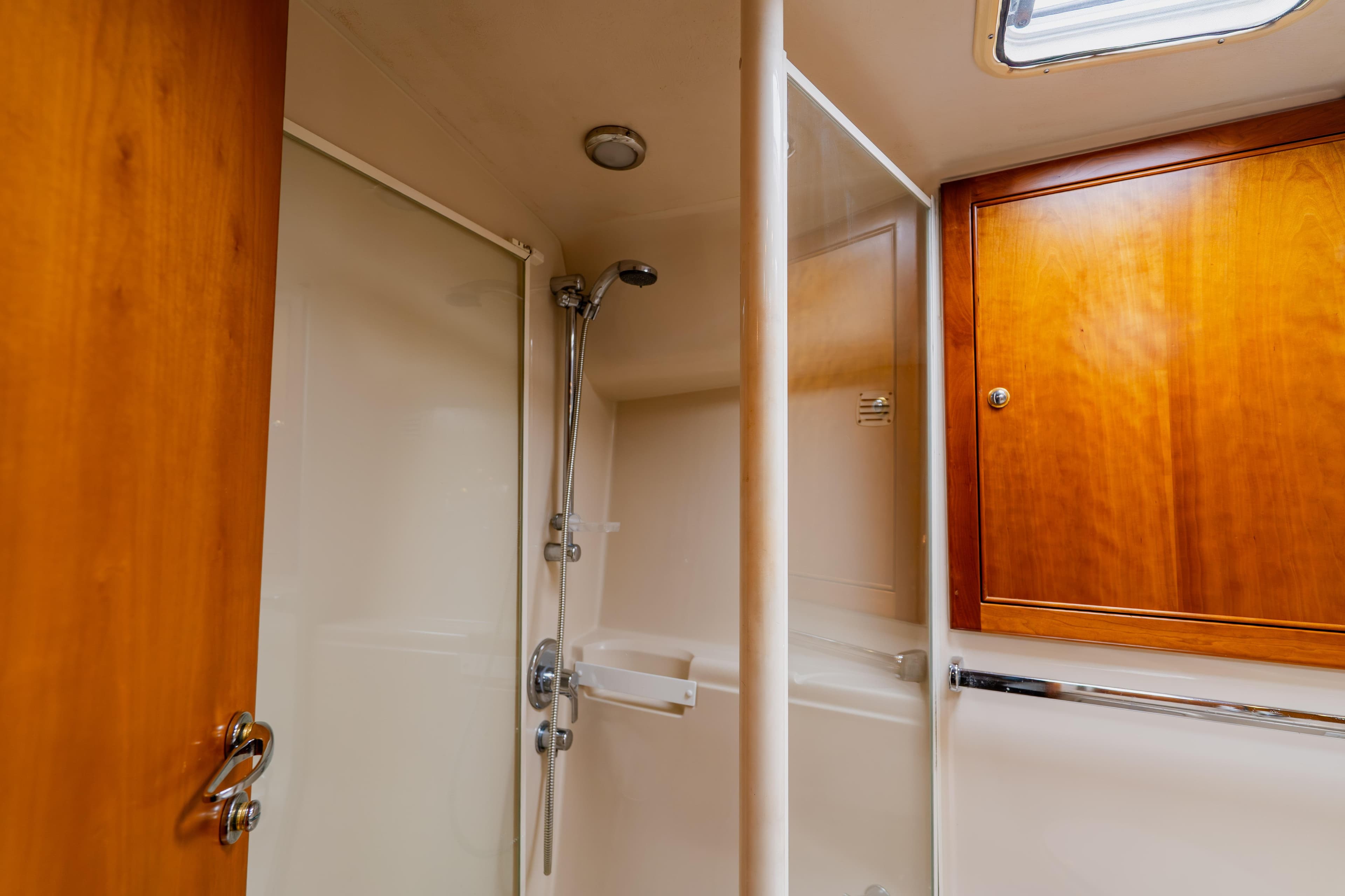 Bathroom interior of 2003 Wellcraft 400 Coastal yacht with wooden cabinetry and shower.