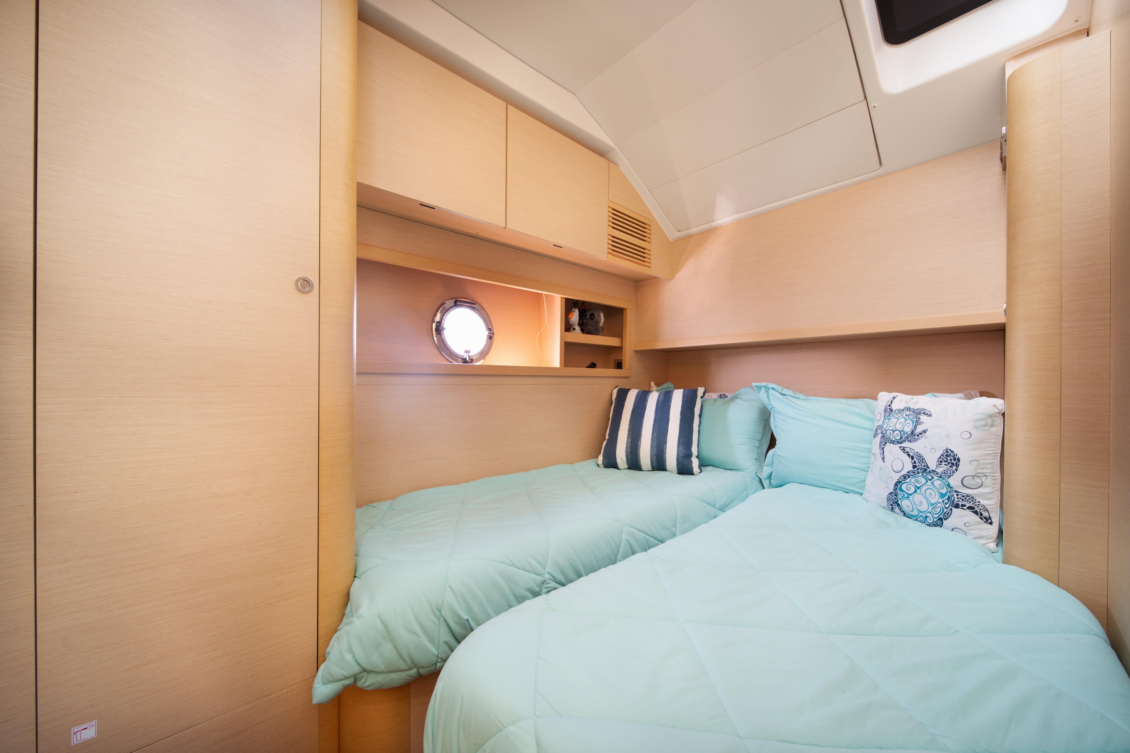 Cozy cabin interior of 2010 Beneteau Monte Carlo 47 yacht with twin beds and nautical decor.