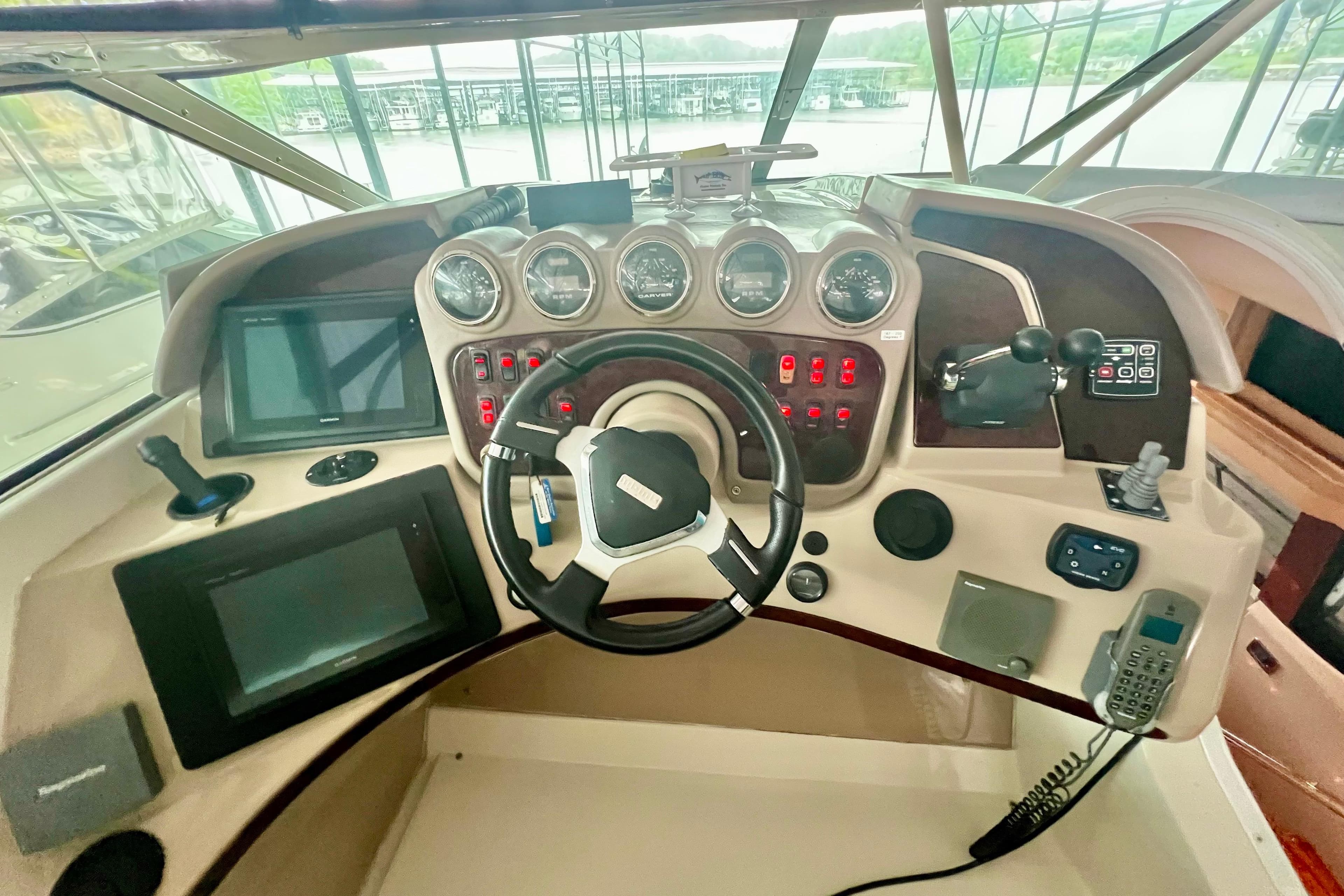 Helm of 2005 Carver 56 Voyager yacht with steering wheel and navigation controls.