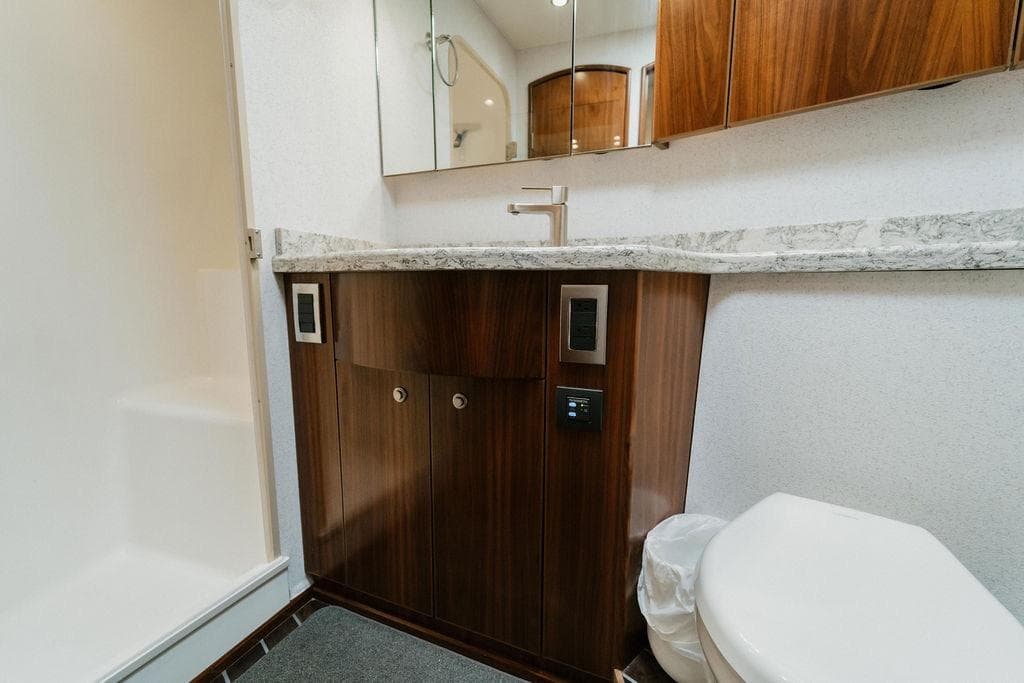 Luxurious bathroom in 2021 Viking 58 Convertible yacht with modern fixtures and wood cabinetry.