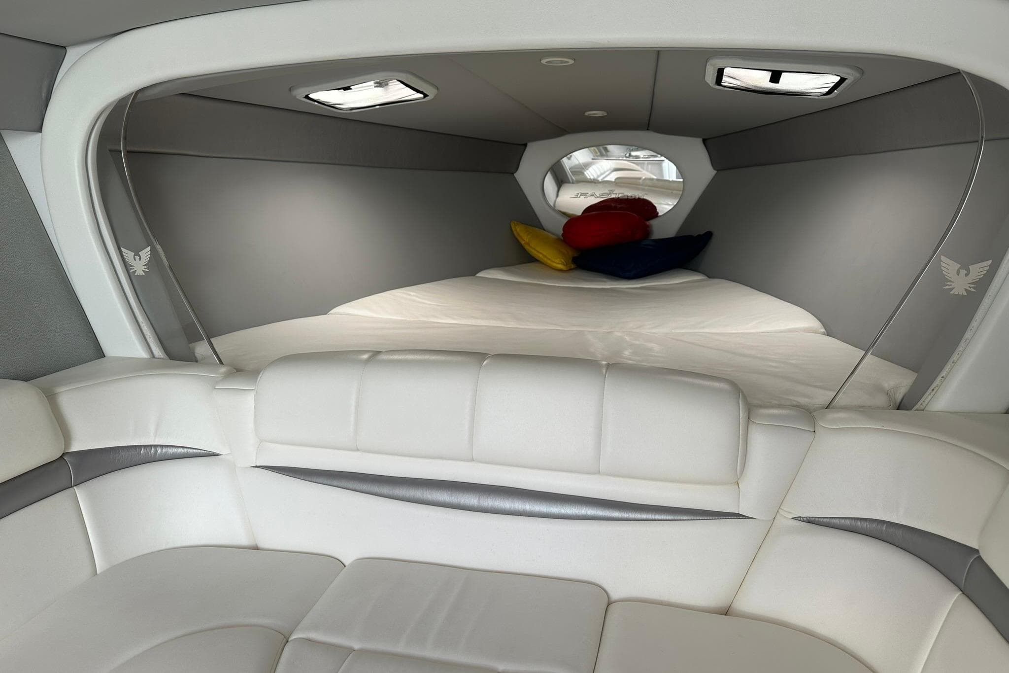 Interior of 2003 Formula 353 FASTech boat with white seating and colorful pillows.