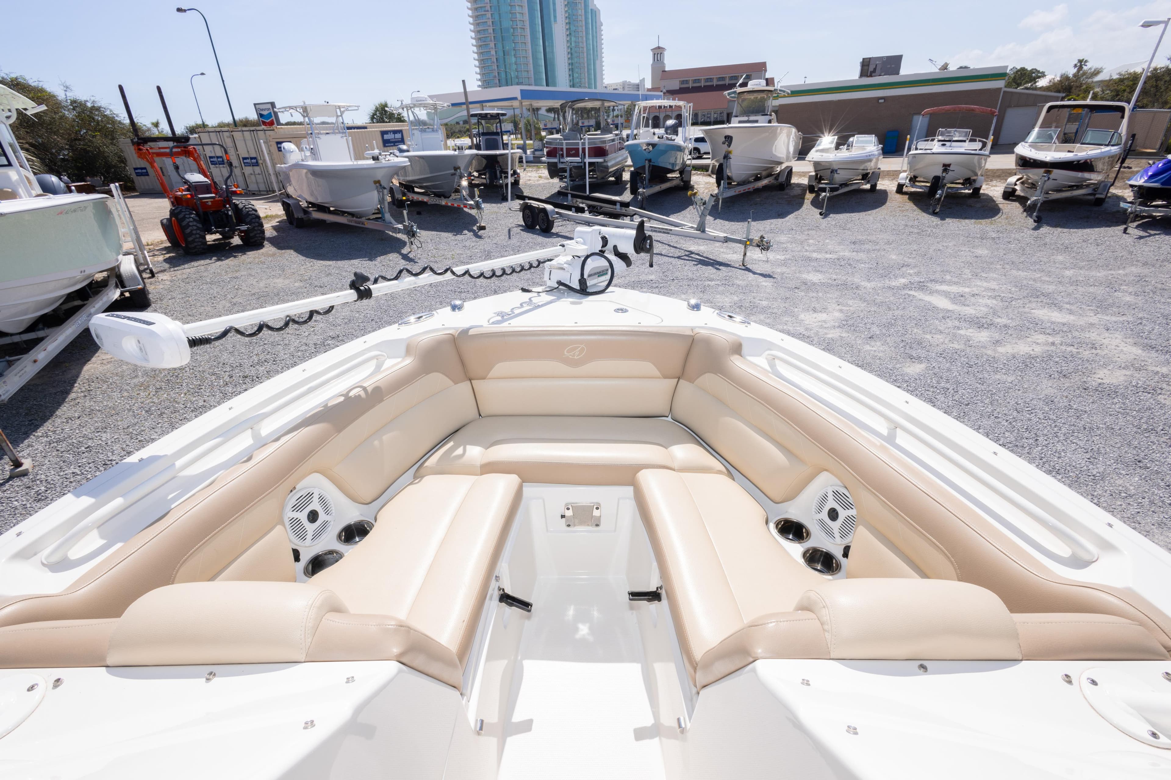 2018 Sailfish 245 DC boat with beige seating, displayed in a marina with other boats.