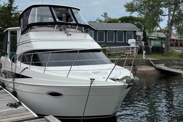 2009 Carver 41 Cockpit Motor Yacht docked by a lakeside cabin.