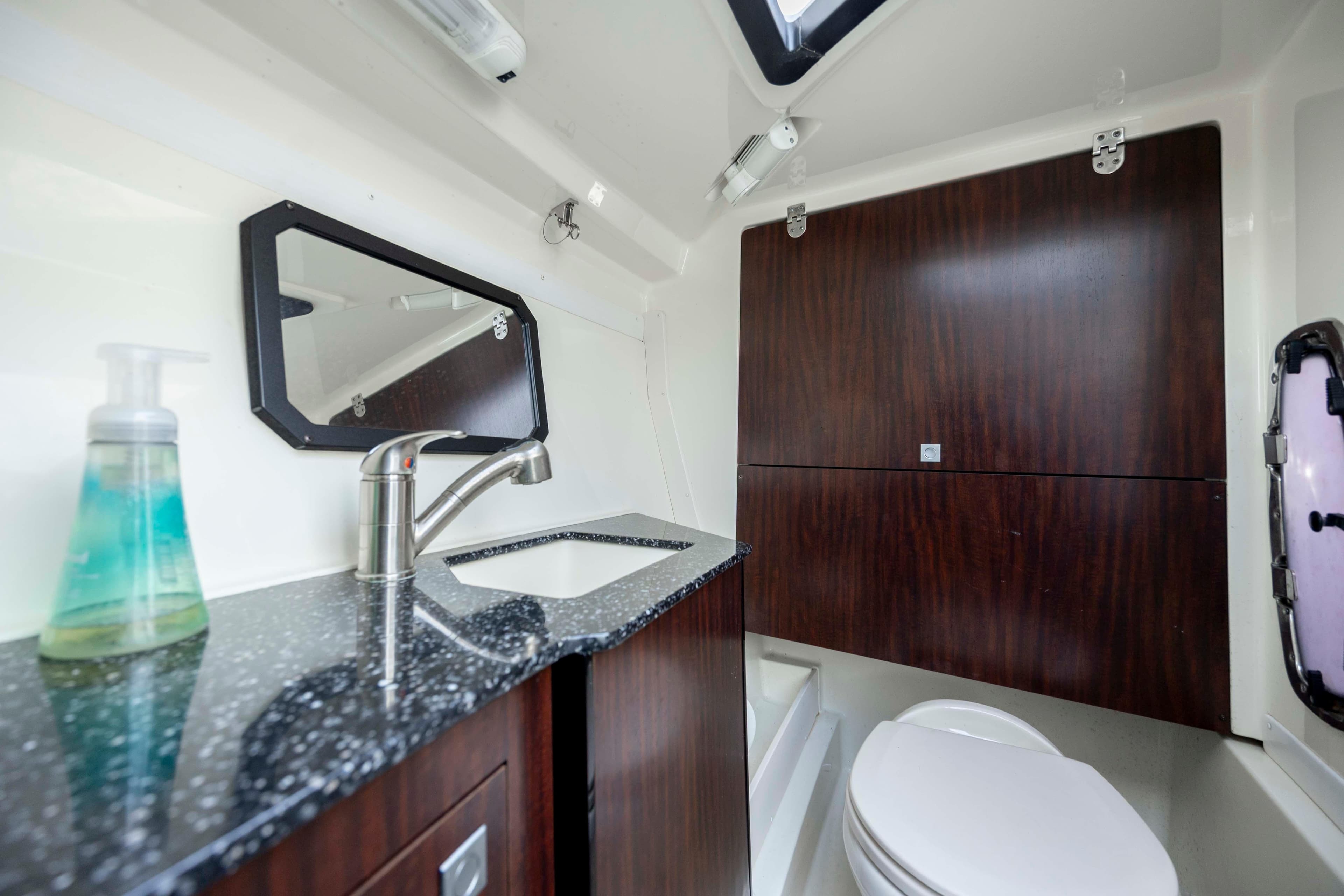 Luxurious bathroom in 2015 Monterey 328SS Super Sport boat with modern fixtures and wood accents.