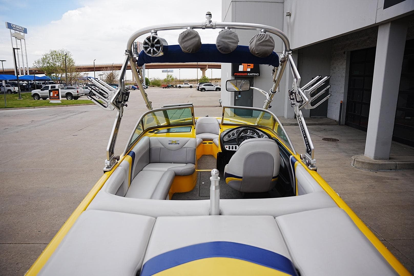 2007 MasterCraft X10 boat with yellow and gray interior, parked outdoors.