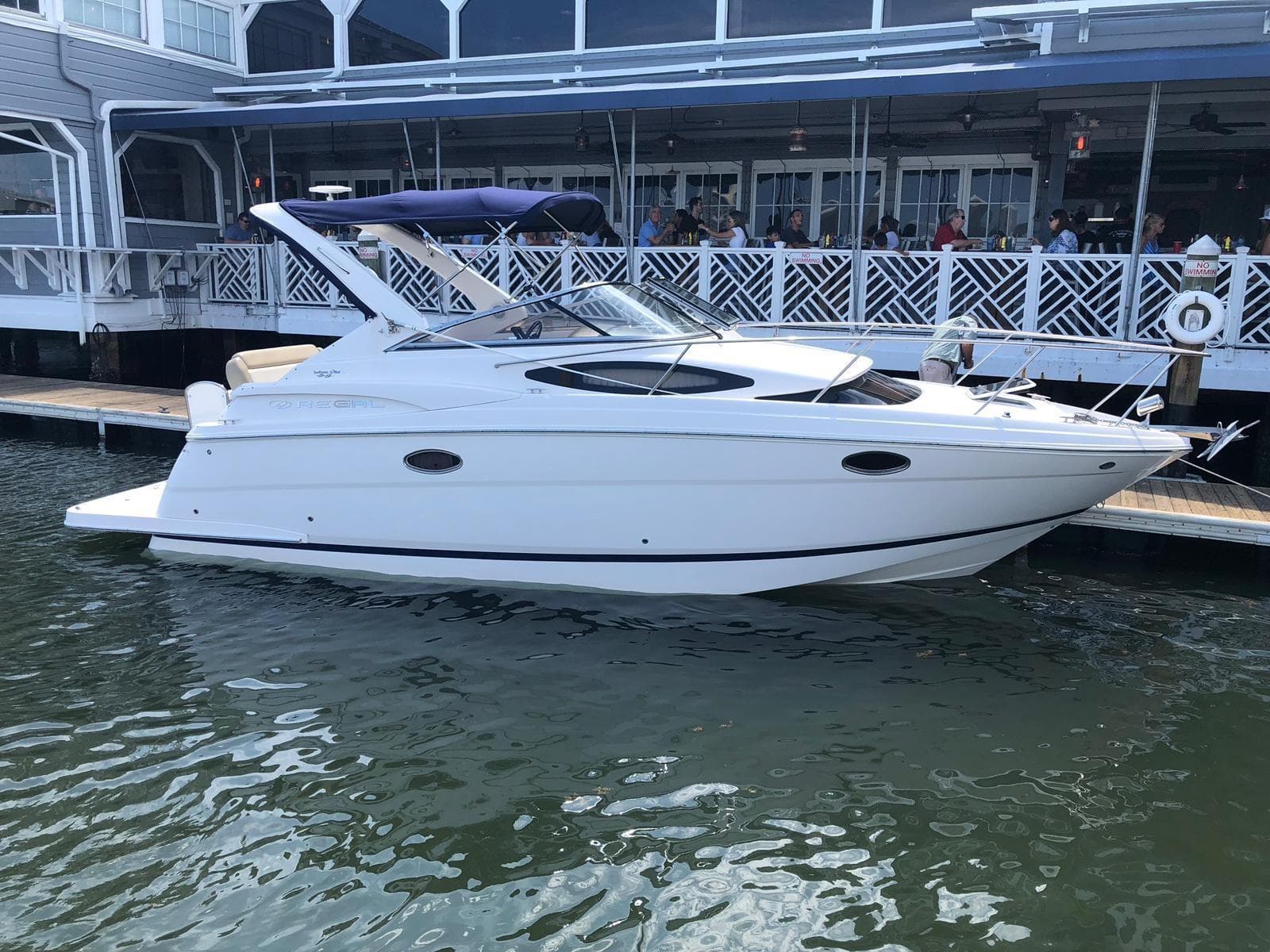 2012 Regal 3060 Express Cruiser docked, white boat.