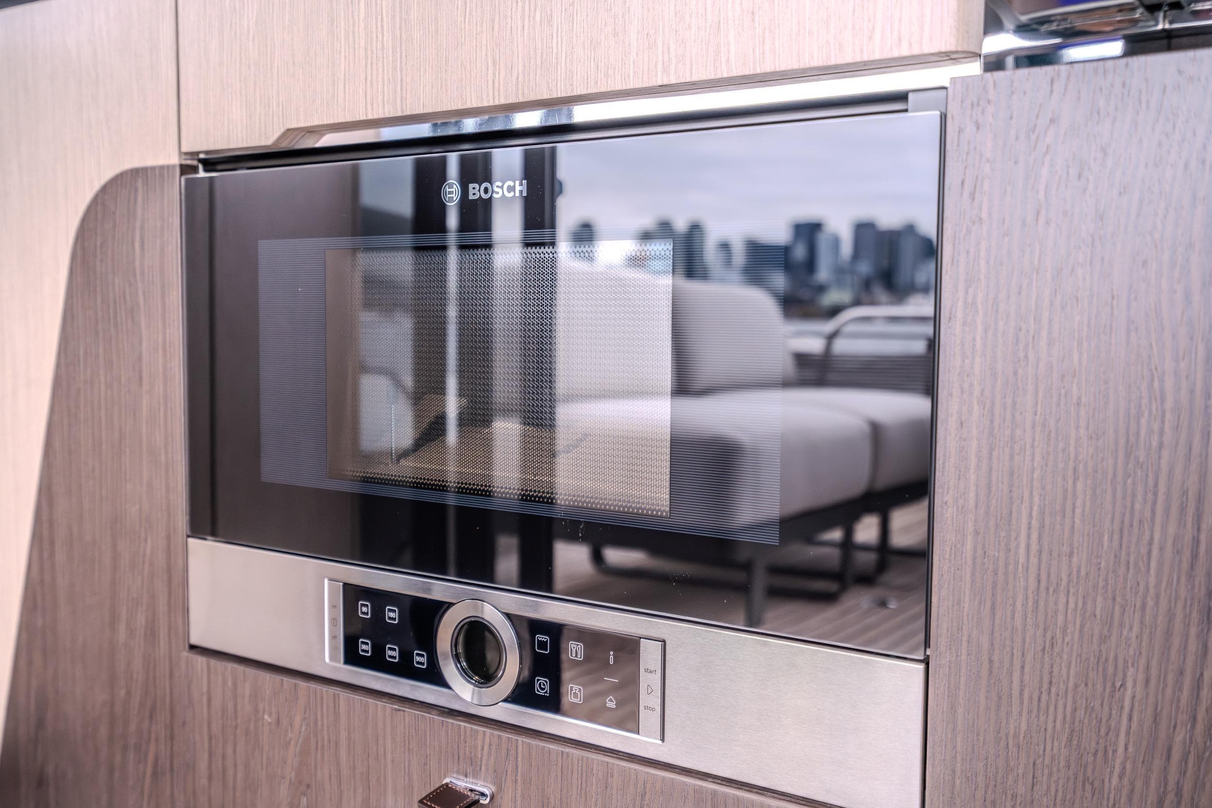 Built-in Bosch microwave in Absolute 48 Coupe yacht, 2026 model, with cityscape reflection.