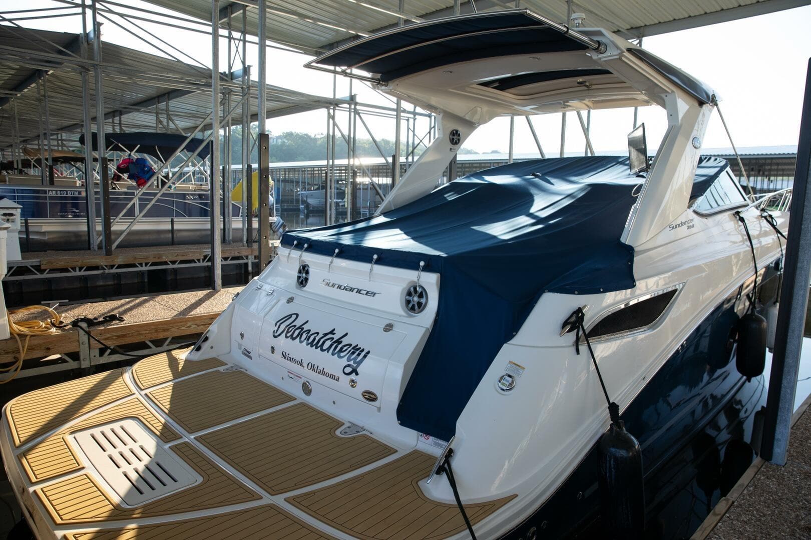 2016 Sea Ray 350 Sundancer docked, covered with blue tarp, in marina setting.