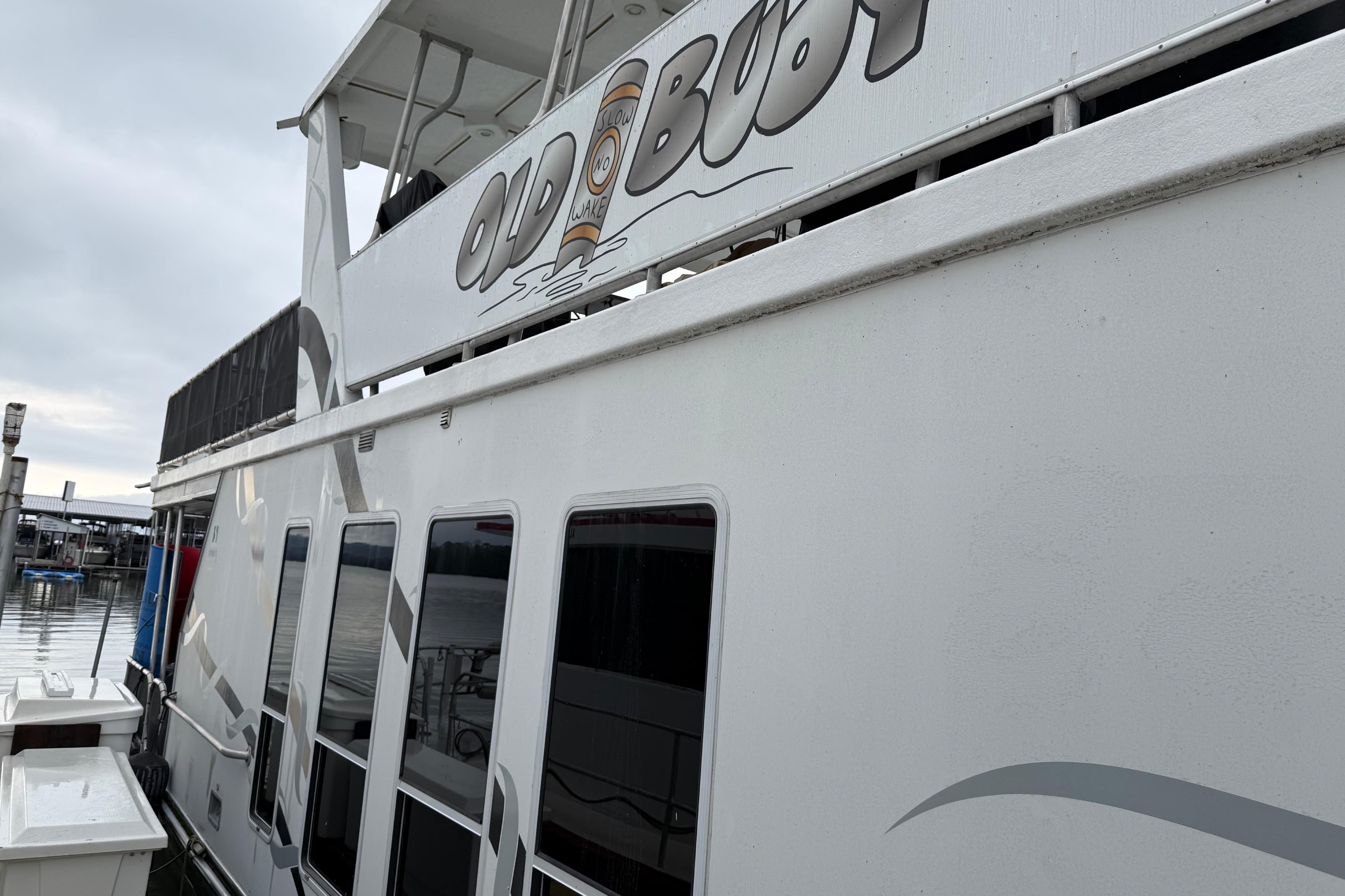 Houseboat "Old Boot" docked, Sharpe 80 X 18, 2001 model, overcast sky.