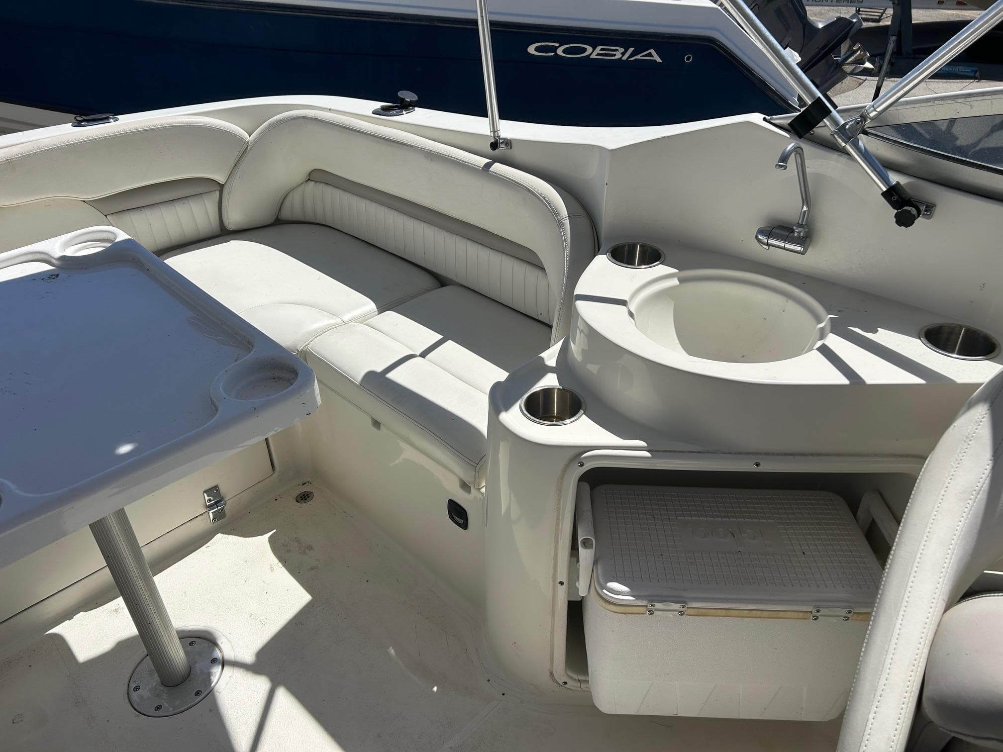 2003 Stingray 240 LR boat interior with seating, table, and sink.