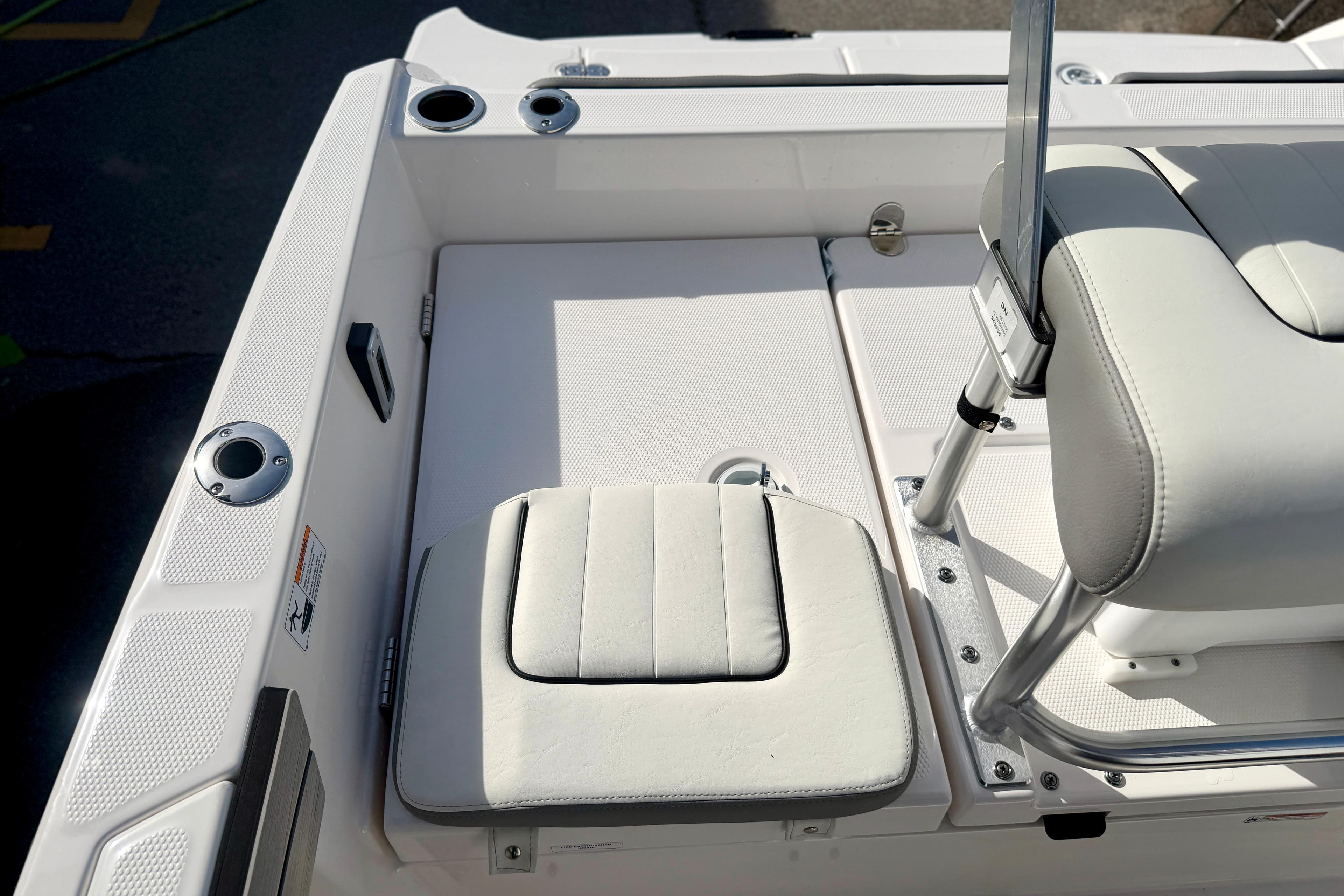 2025 Yamaha Boats 195 FSH Sport interior with white seating and stainless steel fixtures.