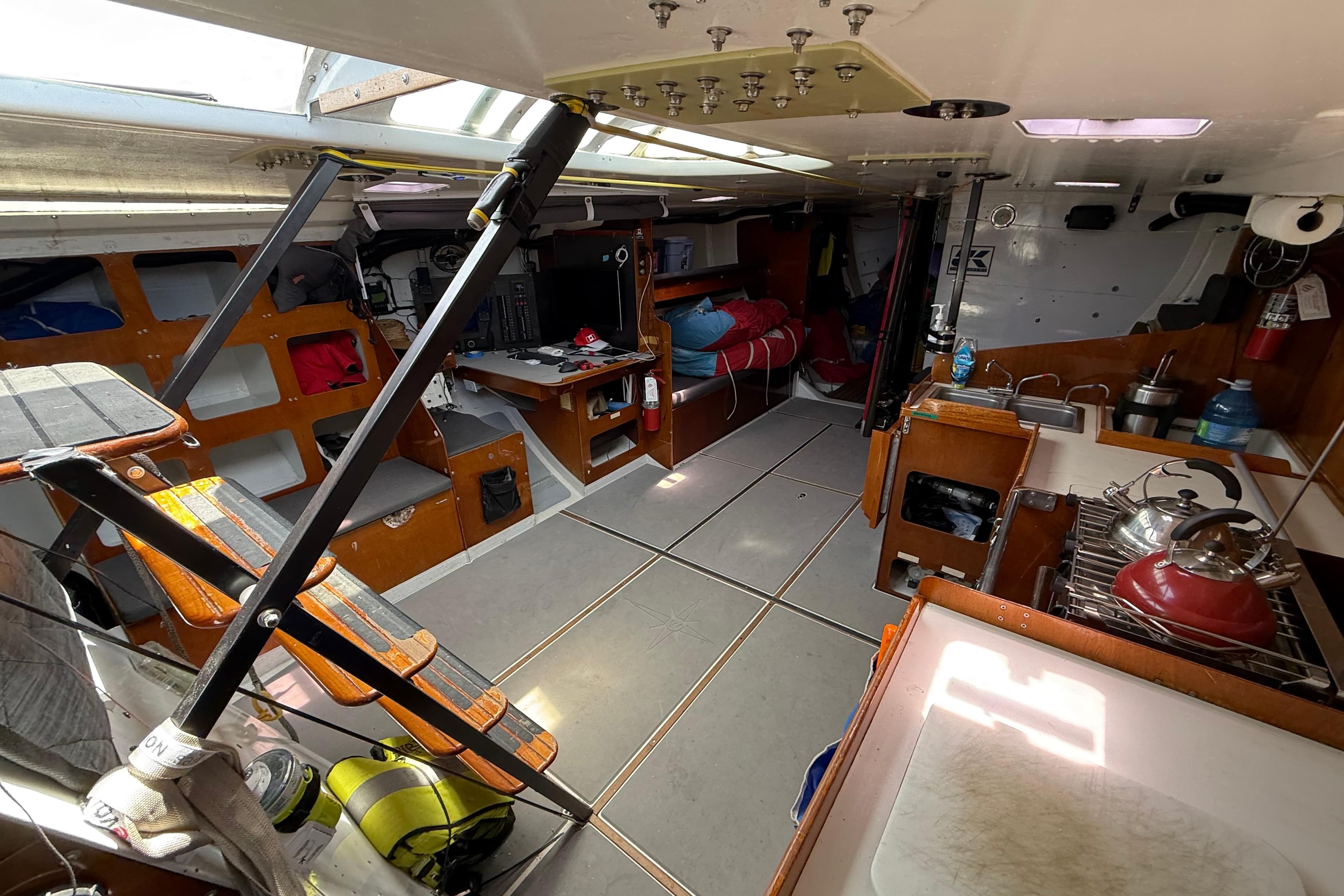 Interior of a 1987 Santa Cruz 70 sailboat with kitchen and seating area.