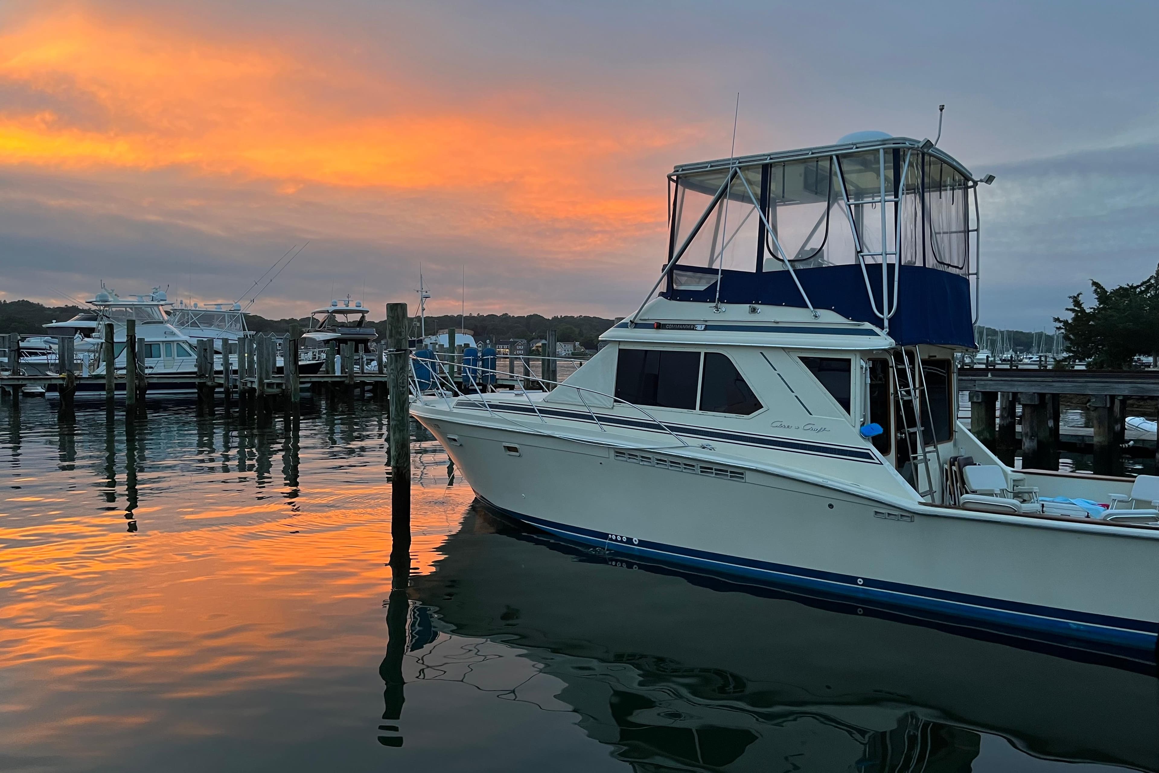 1987 Chris-Craft 392 Commander yacht docked at sunset, reflecting on calm water.