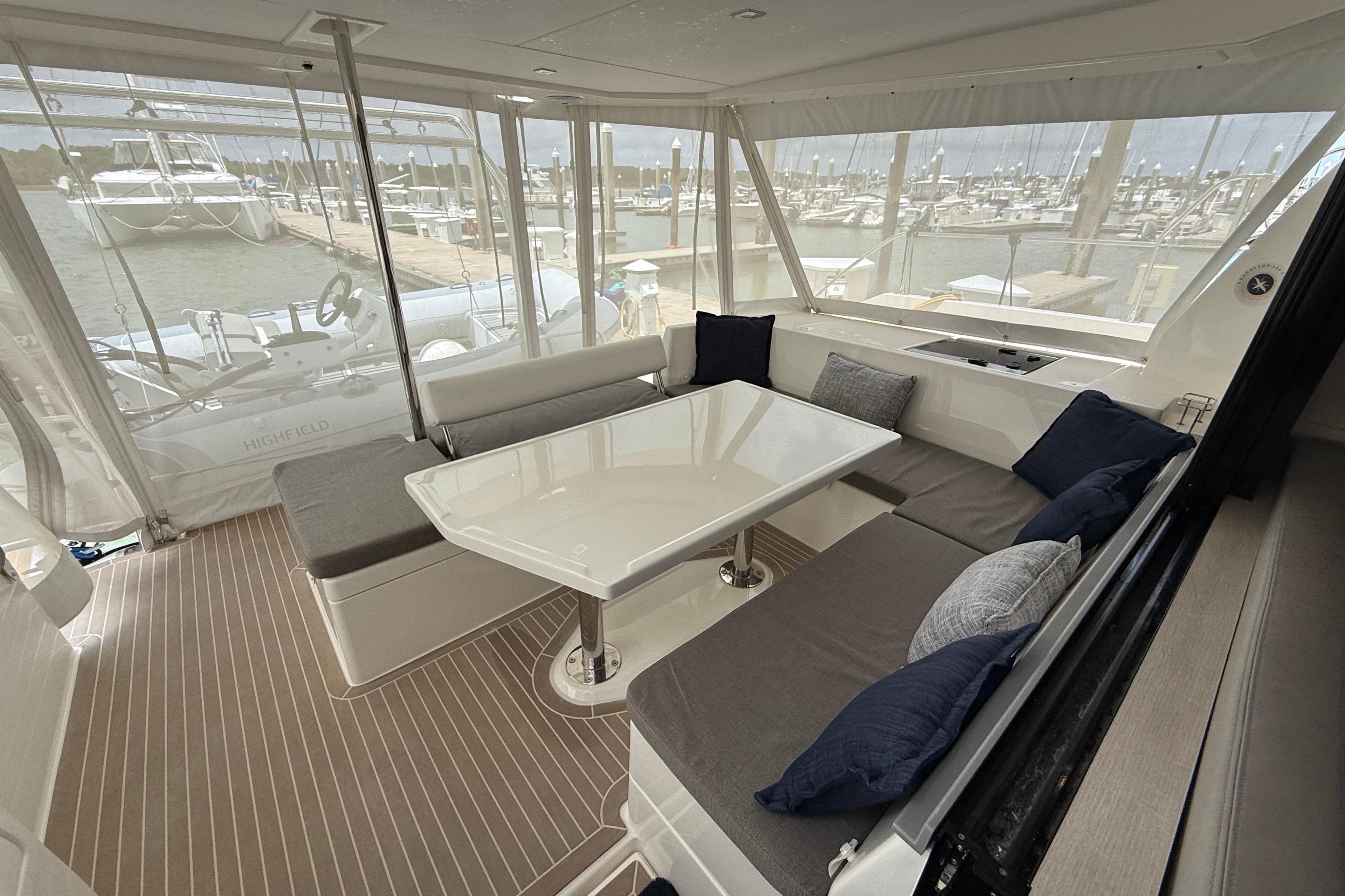 2021 Leopard 43 Powercat interior with seating, table, and marina view.