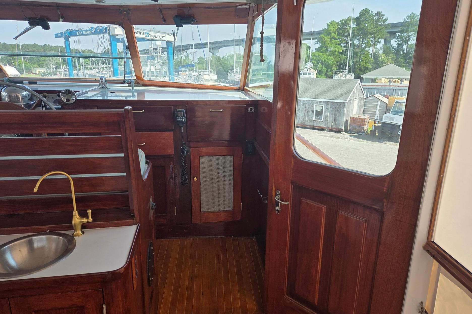 Interior of a 1966 Trumpy 55 boat with wooden finish and brass fixtures.