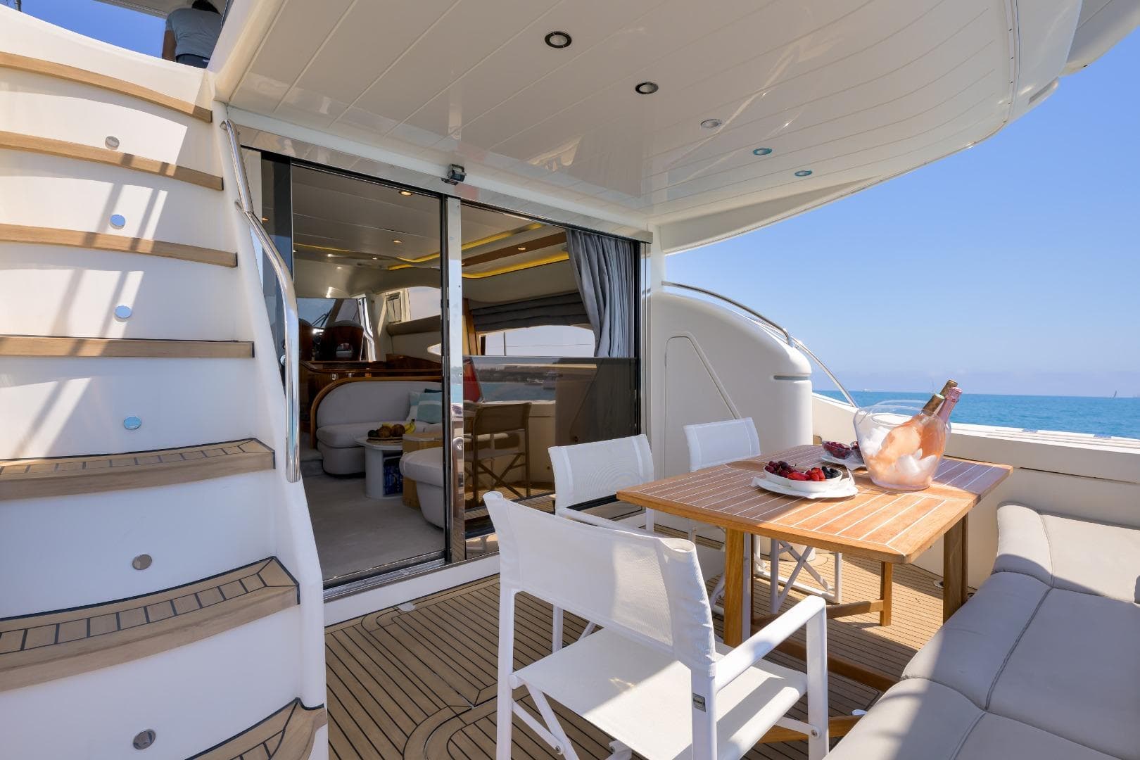 Luxurious 2001 Princess 61 yacht deck with dining area, ocean view, and elegant interior.