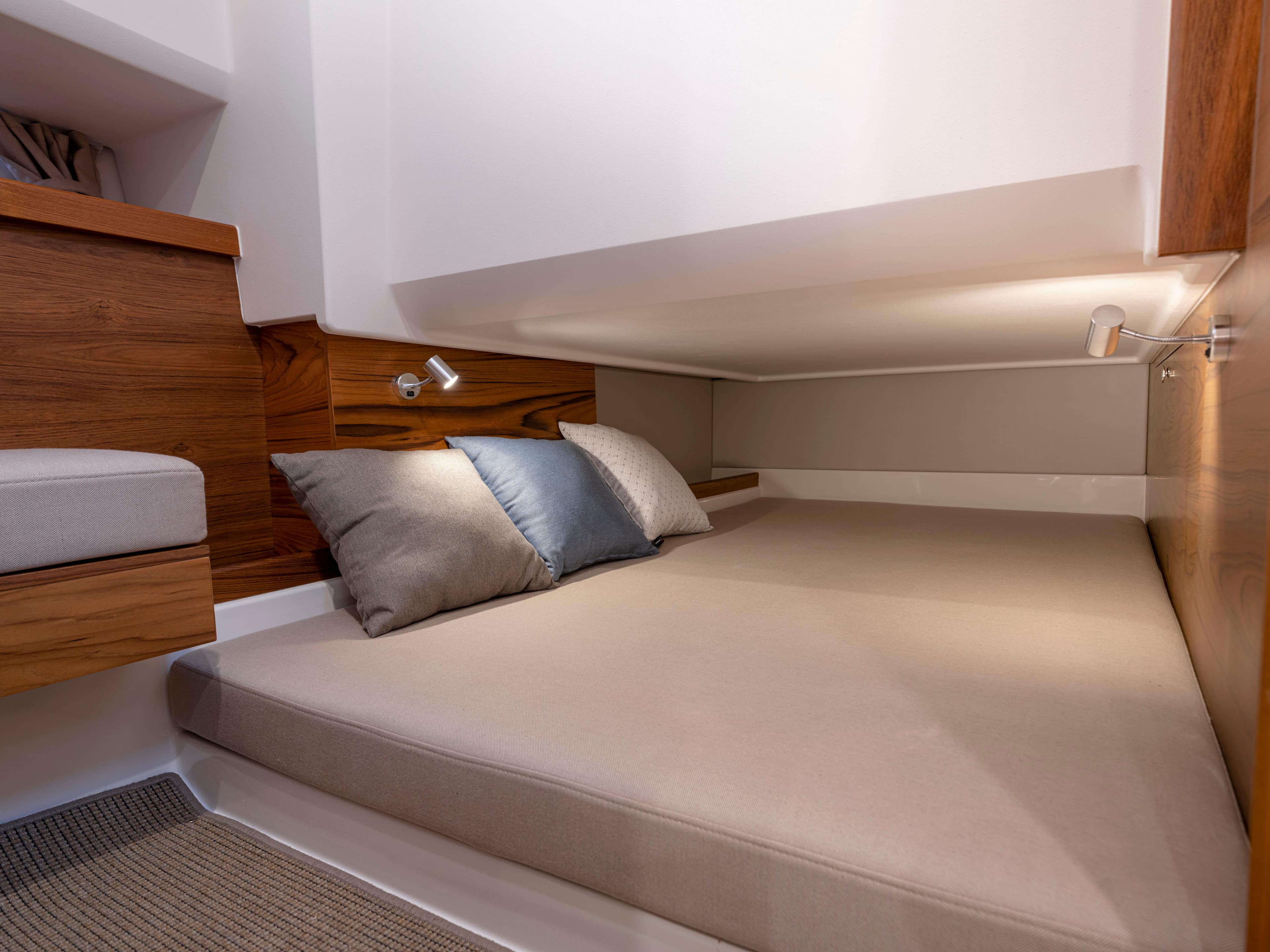 2024 Nimbus C11 cabin interior with cozy bed and wooden accents.