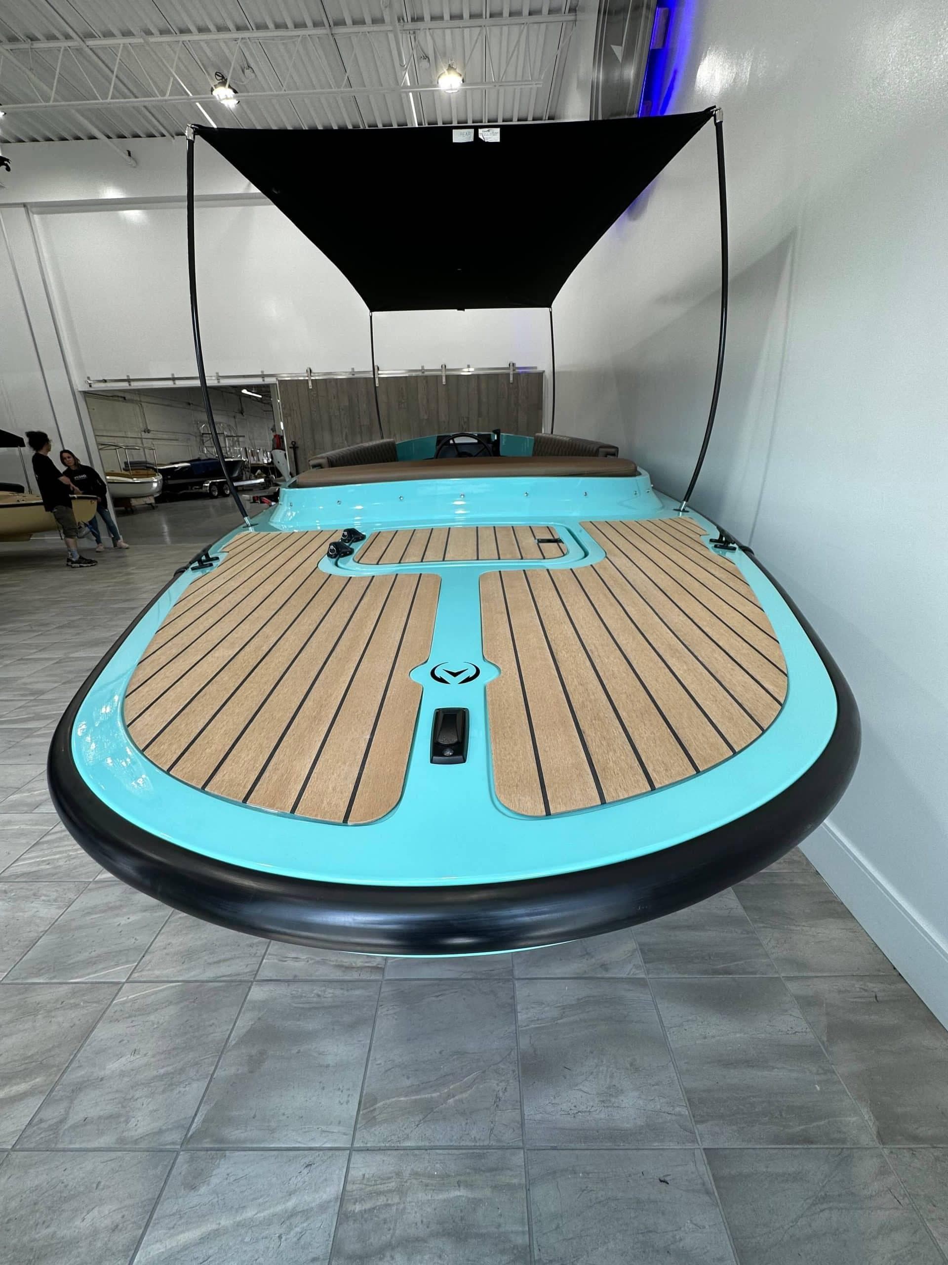 2023 Vision Marine Technologies Fantail 217 boat with turquoise and wood deck, indoor display.