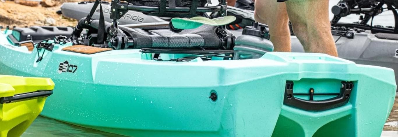 Bonafide SS107 2023 model kayak in turquoise, docked in shallow water.