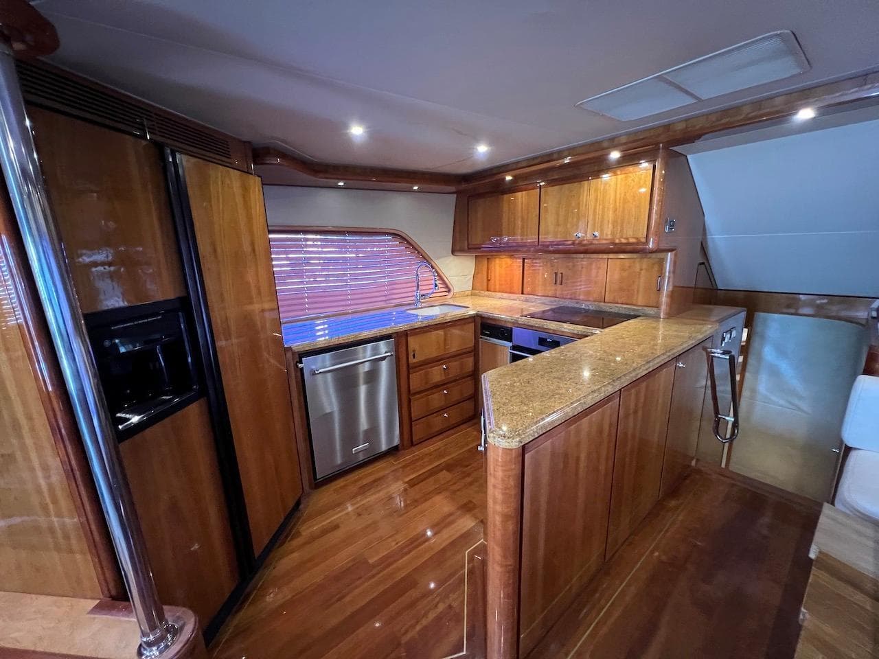 Luxurious kitchen interior of a 2004 Bertram 670 yacht with wooden cabinetry and modern appliances.