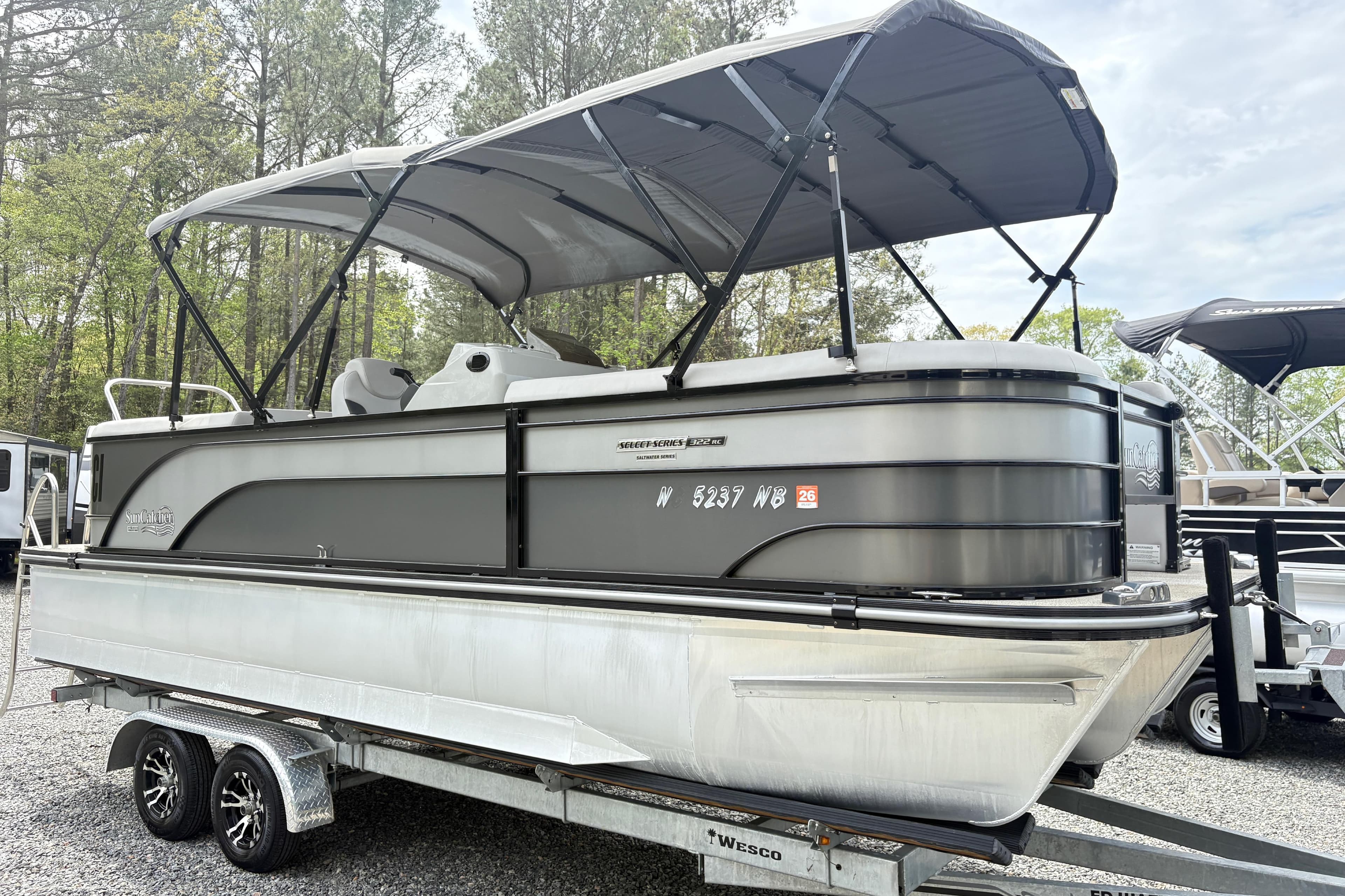 2023 SunCatcher X322 RC pontoon boat on trailer, parked outdoors.