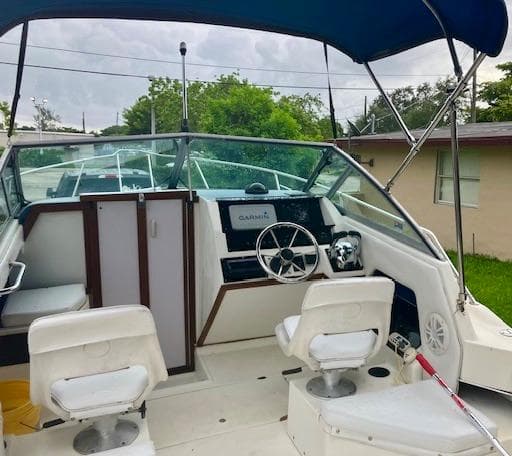 1990 Sea Ray 240 Sundeck boat interior with helm, seats, and canopy.