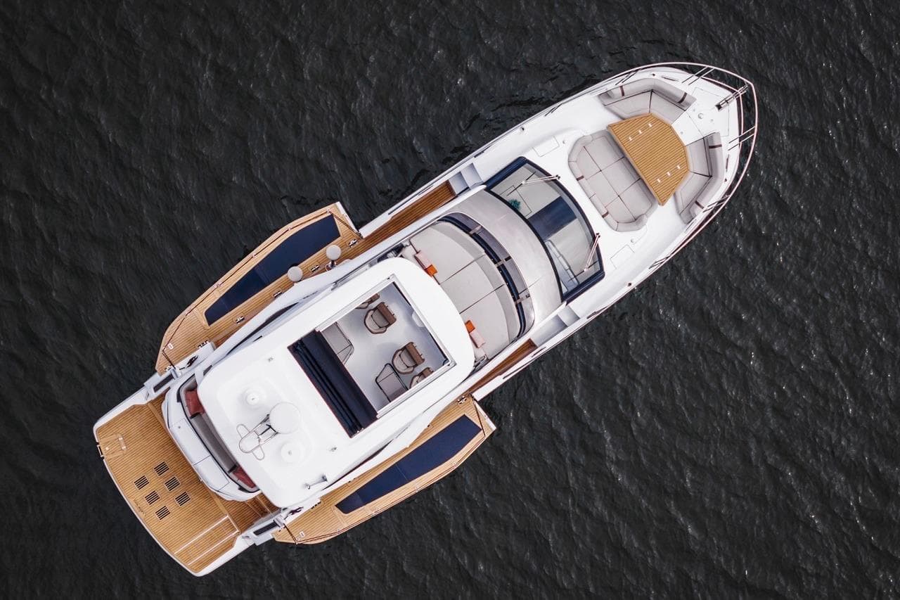 Aerial view of 2026 Galeon 520 Fly yacht on water, showcasing sleek design and spacious deck.