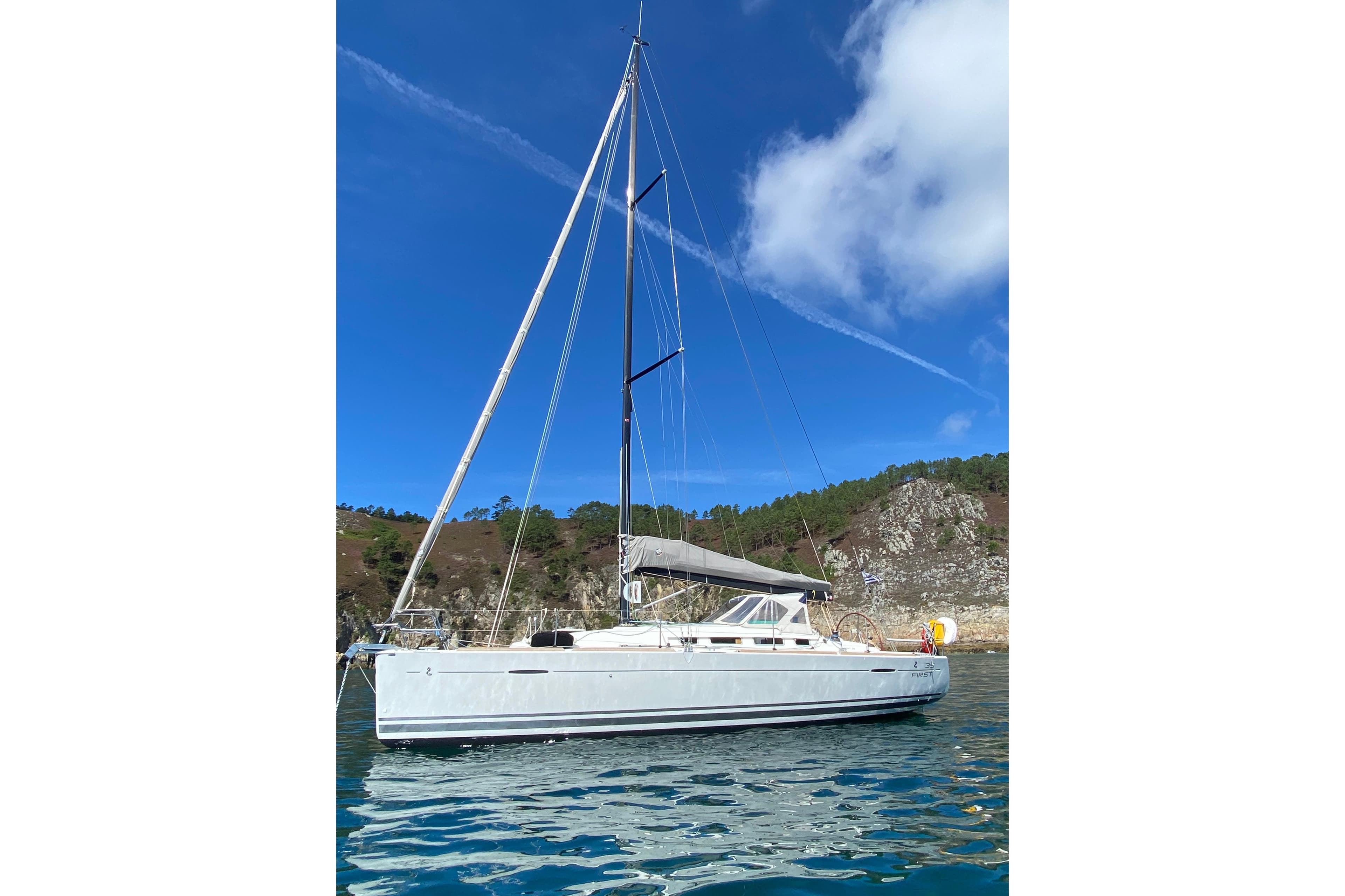 2011 Beneteau First 35 sailboat on calm water, clear blue sky background.