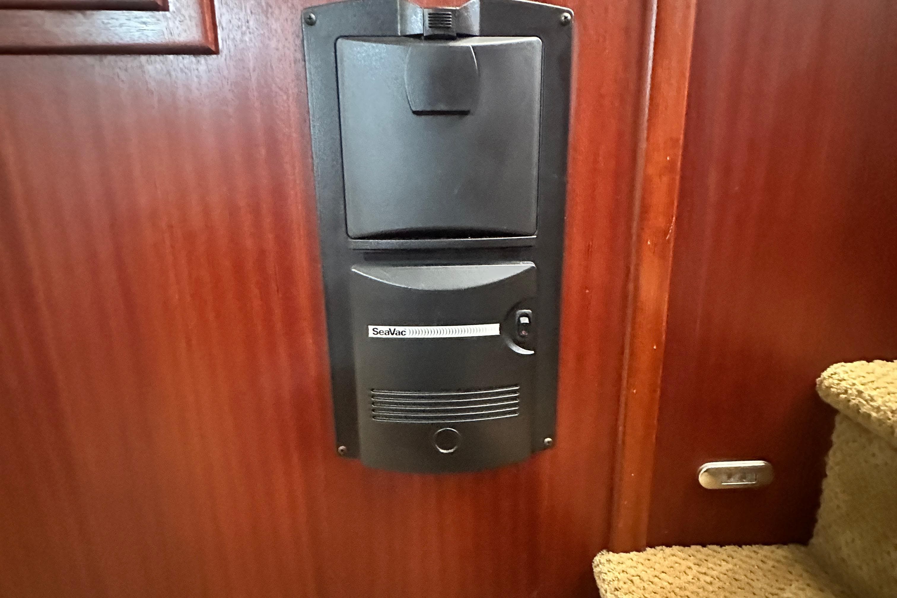 SeaVac vacuum system on 2006 American Tug 41, mounted on wooden wall near carpeted stairs.