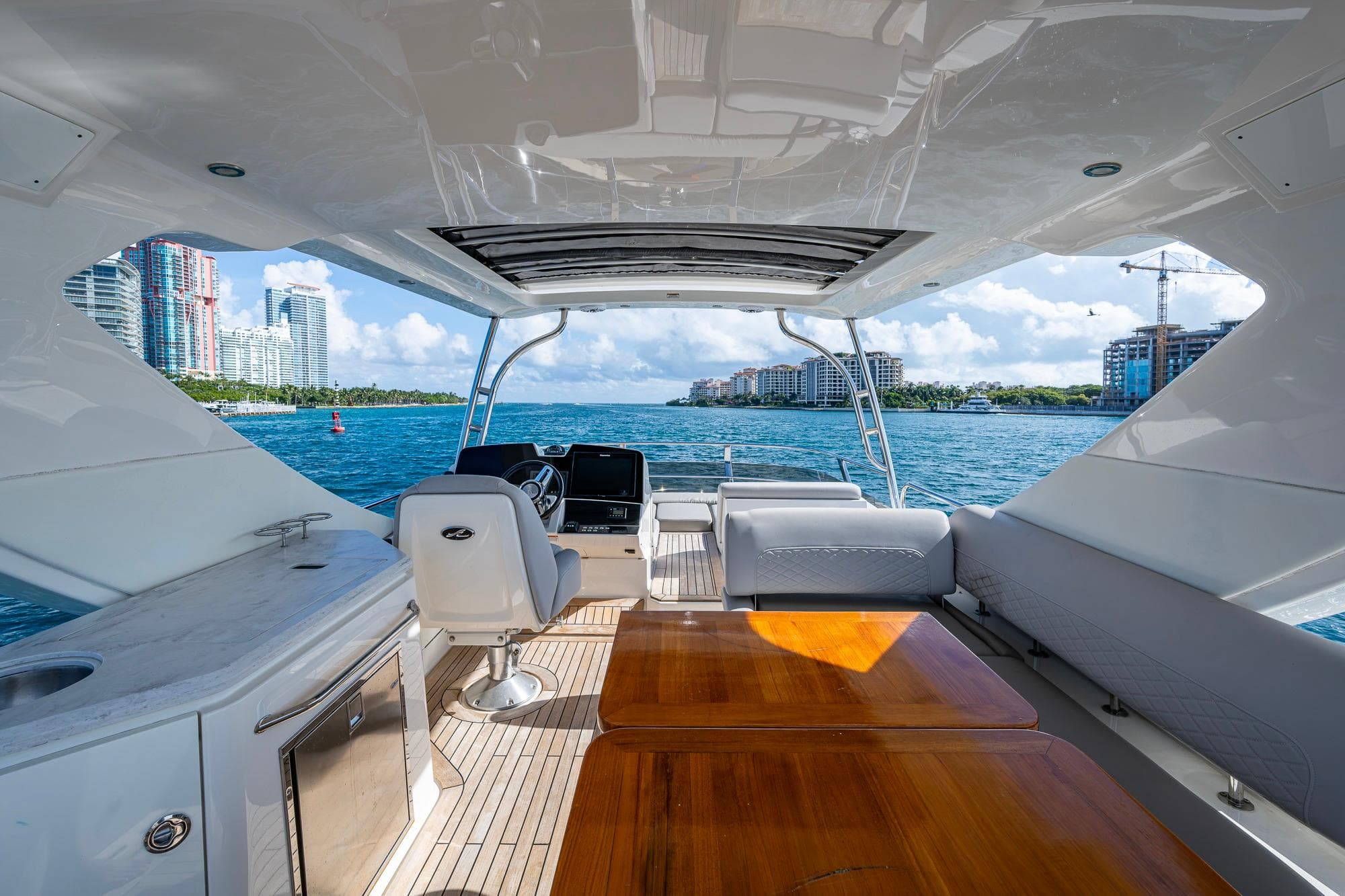Luxurious 2018 Sea Ray L550 Fly yacht interior with ocean view and city skyline.