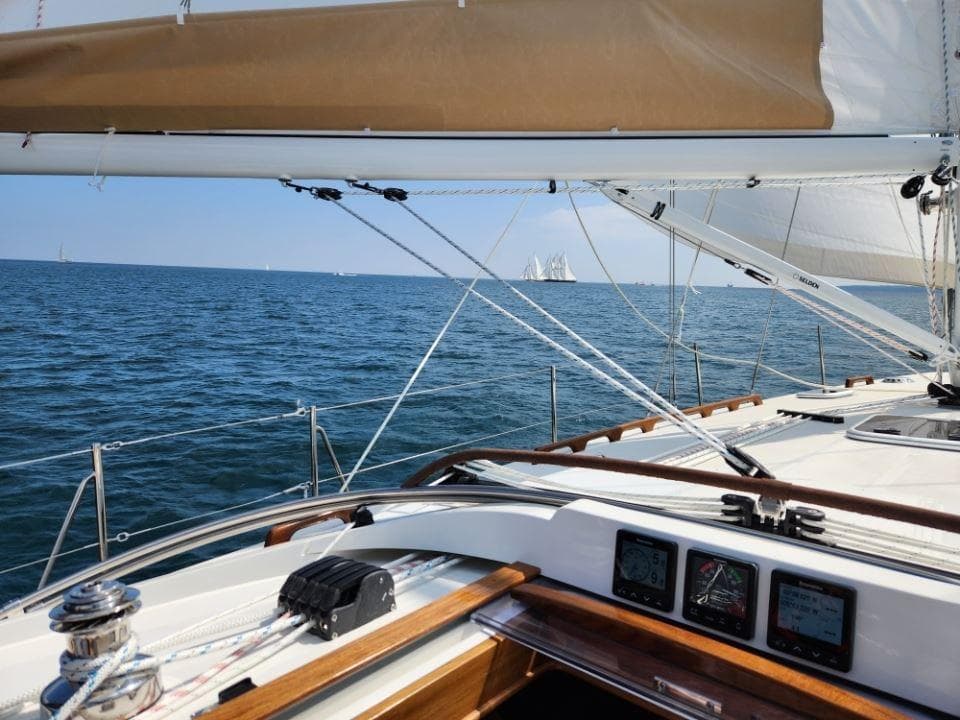 2025 Rustler 37 sailboat on open sea, clear skies, visible sails and navigation instruments.