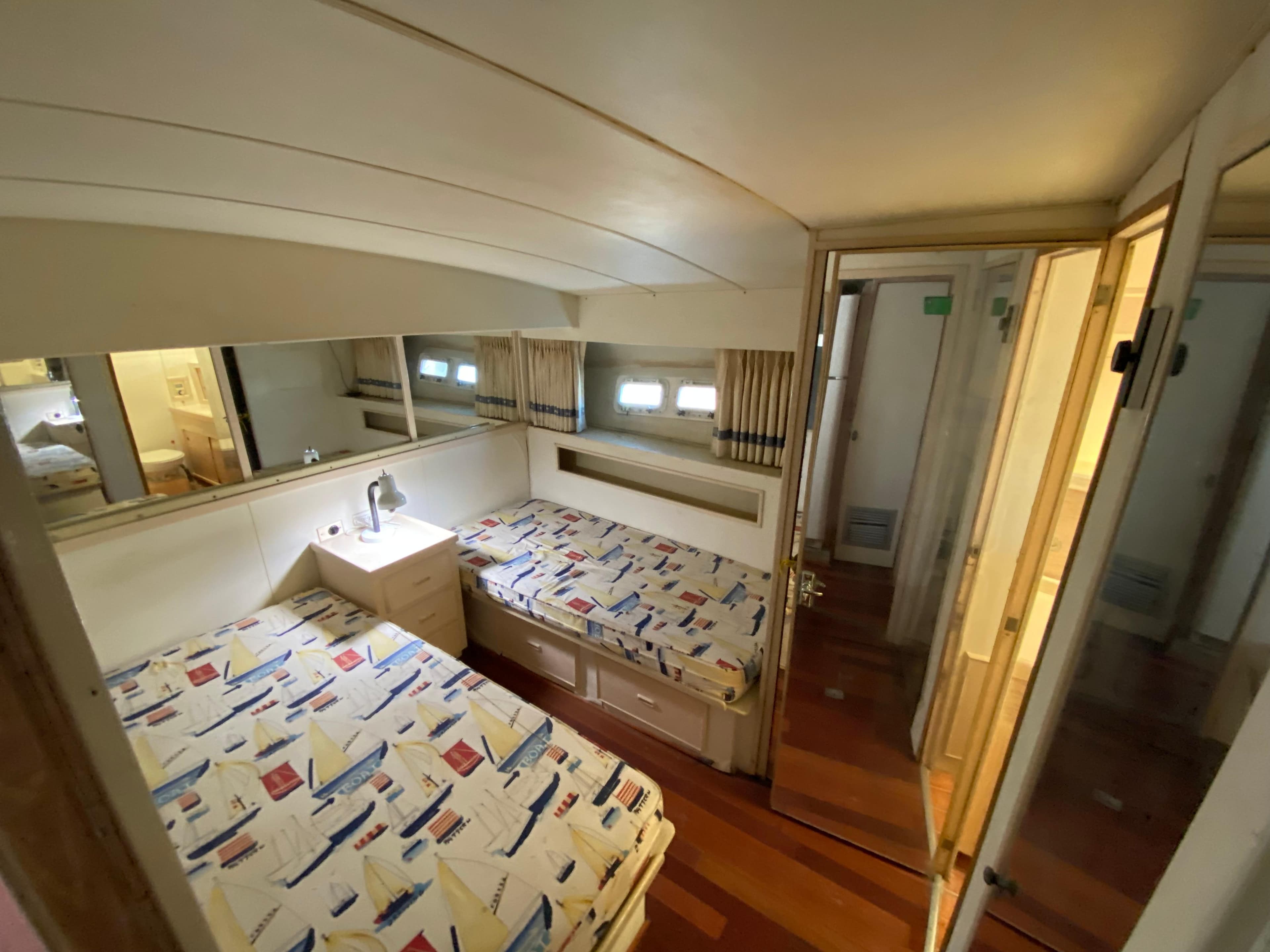 Interior cabin of 1982 Bertram 46.6 War Wagon with twin beds and nautical decor.