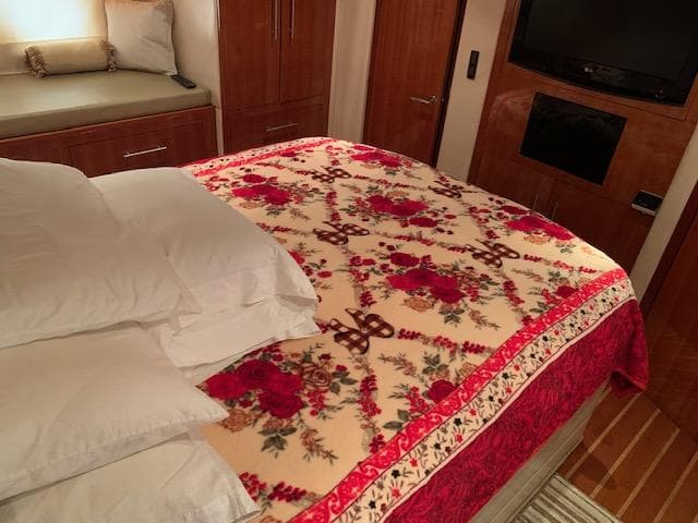 Luxurious bedroom interior of 2015 Regal 42 Sport Coupe with floral bedspread.
