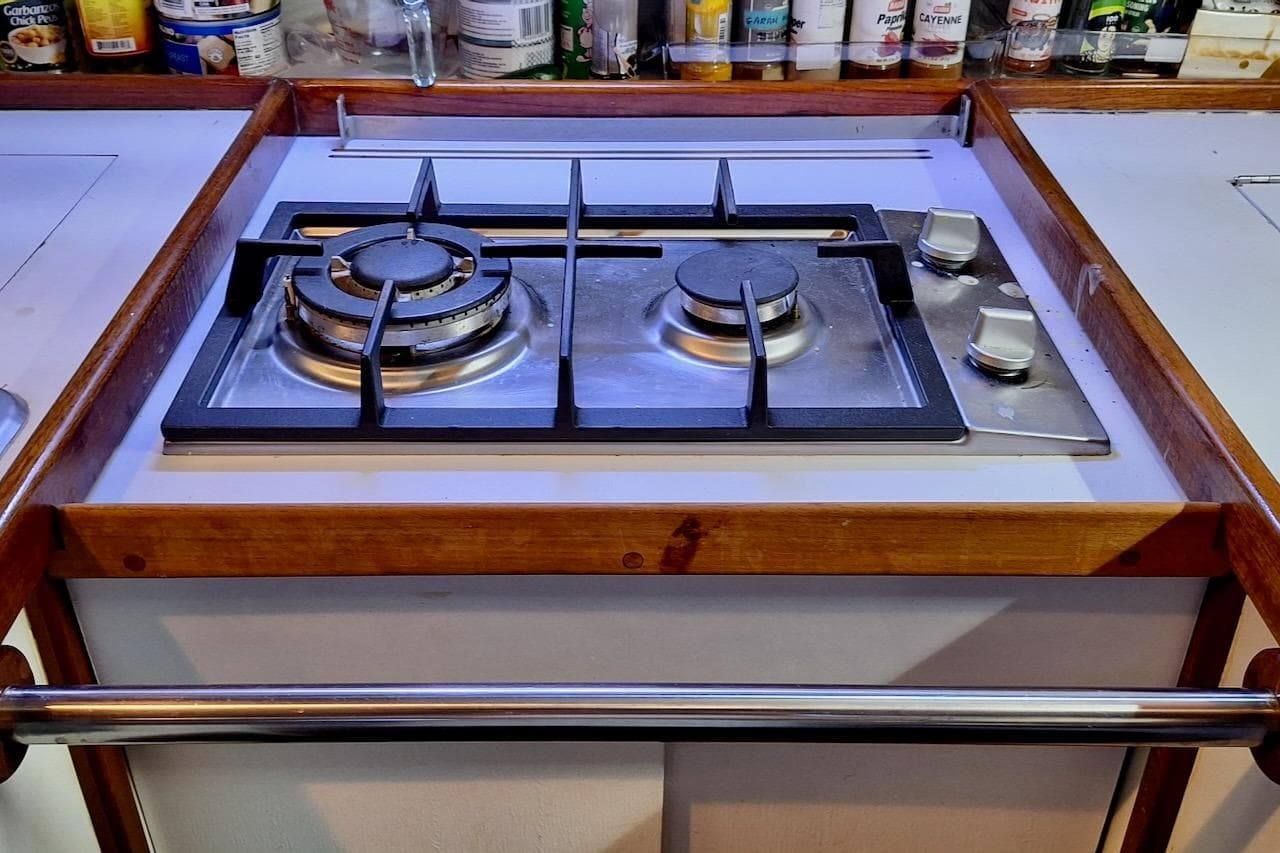 Stove in 1989 Morgan 44 CC yacht kitchen with wooden trim and spice rack.