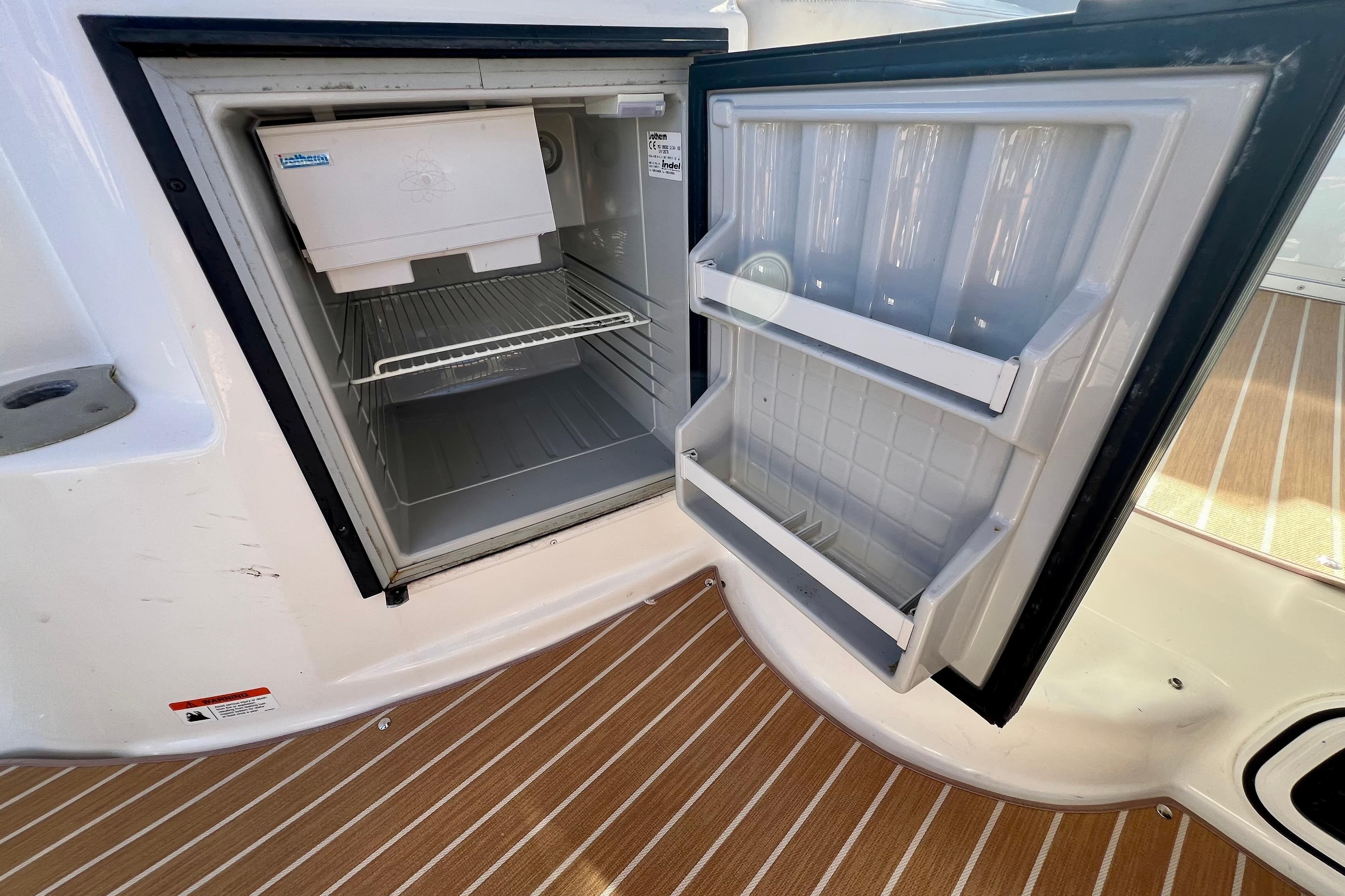 Open refrigerator on 2007 Larson Cabrio 310 boat, showcasing interior shelves and ice maker.